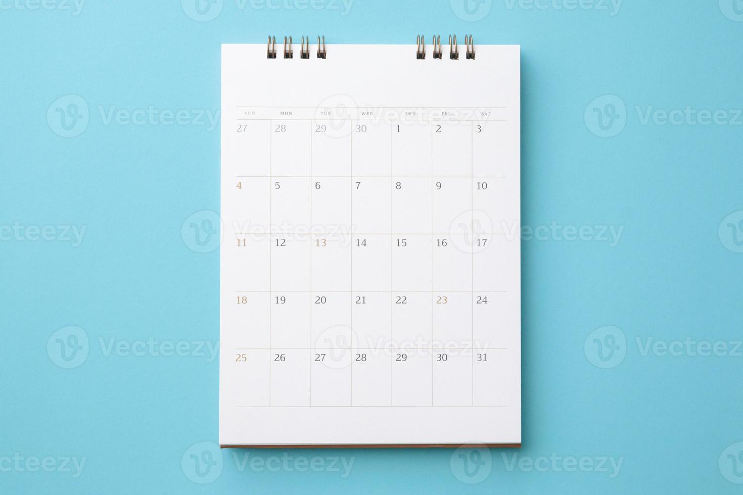 calendario de escritorio sobre fondo azul concepto de reunión de cita de planificación empresarial foto