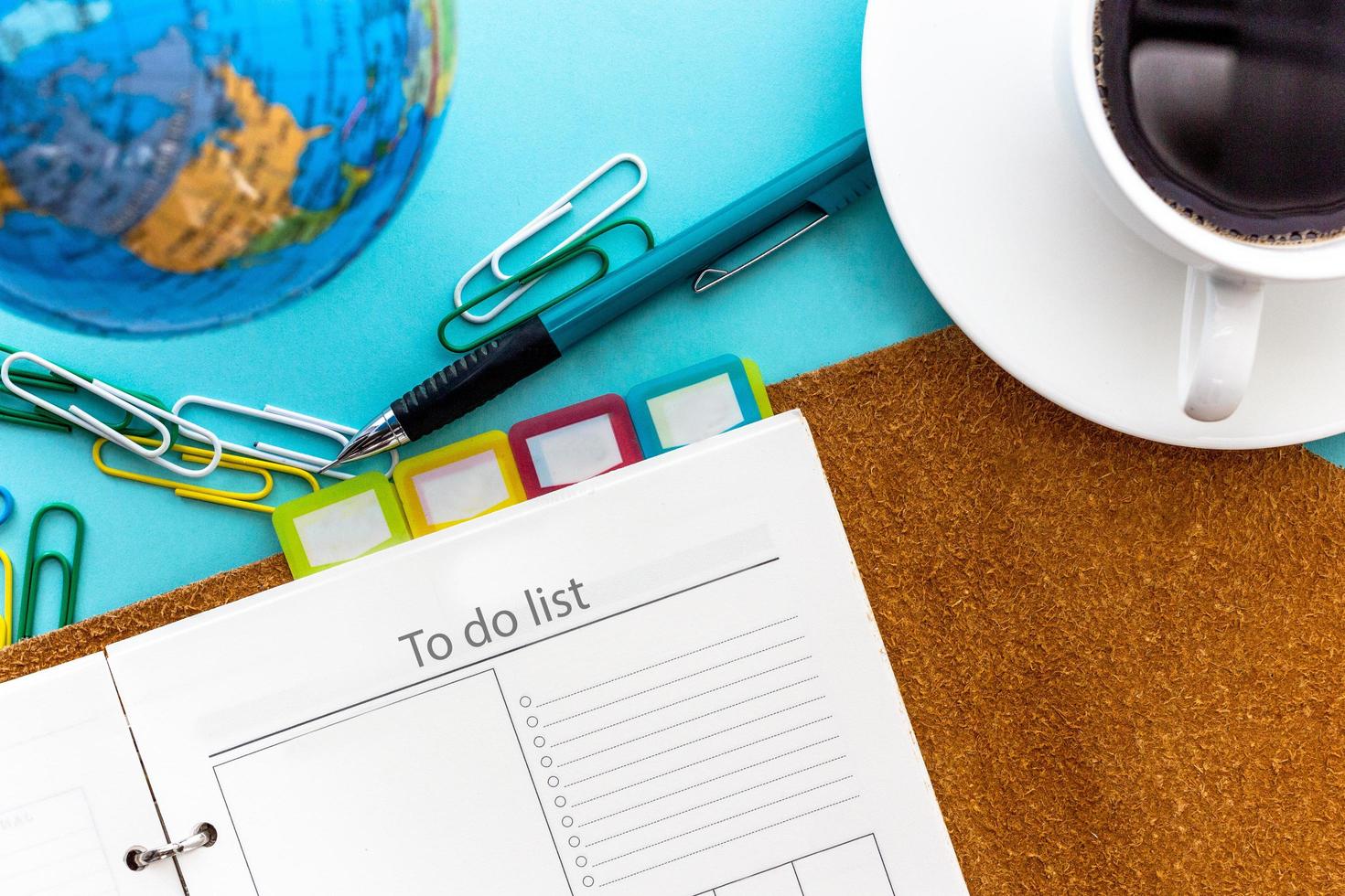 To do list or check list setting page concept on planner with mechanical pencil and black coffee on blue background in top view photo