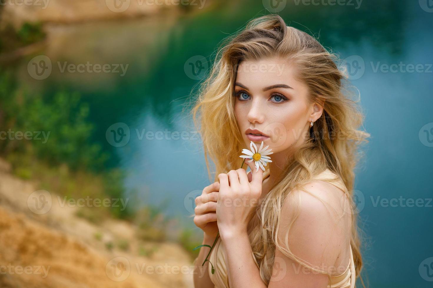 retrato de una chica hermosa con una margarita en las manos, hermoso maquillaje foto