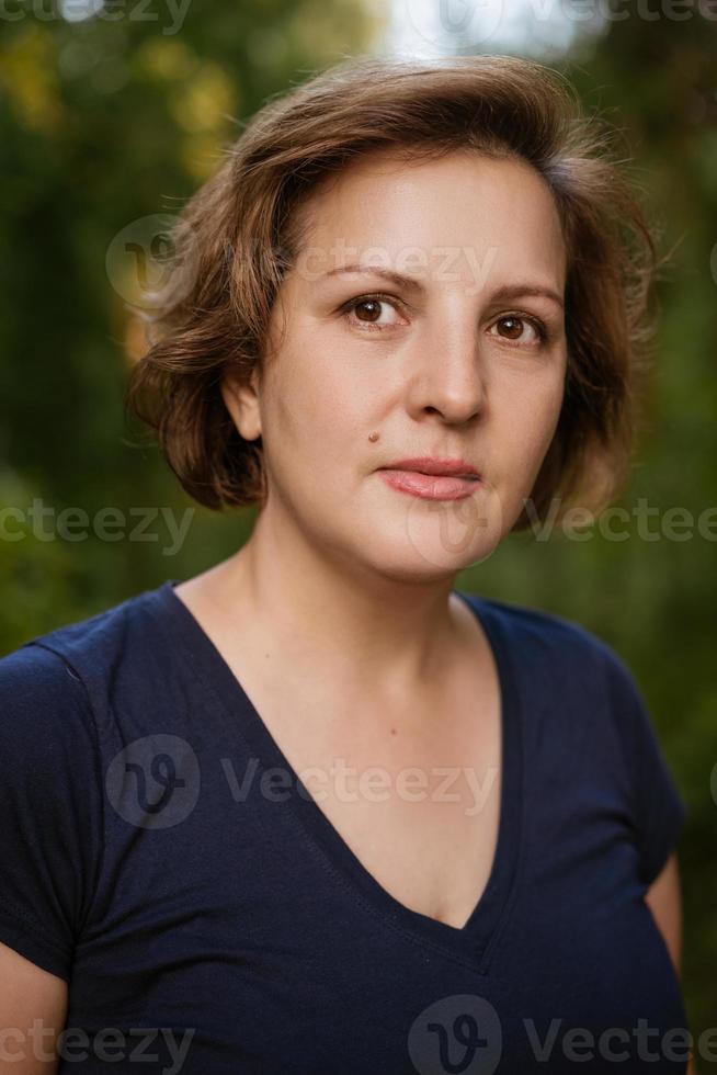 Close-up adult woman portrait against natural jelly background happy and calm photo