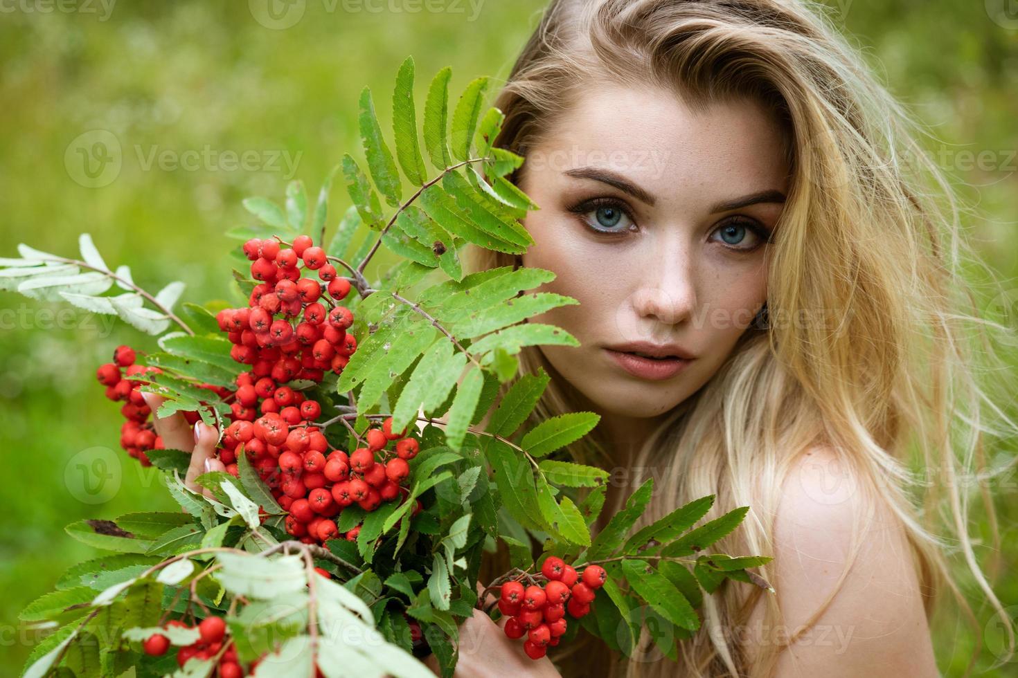 Portrait of a beautiful woman with a bouquet of rowan photo