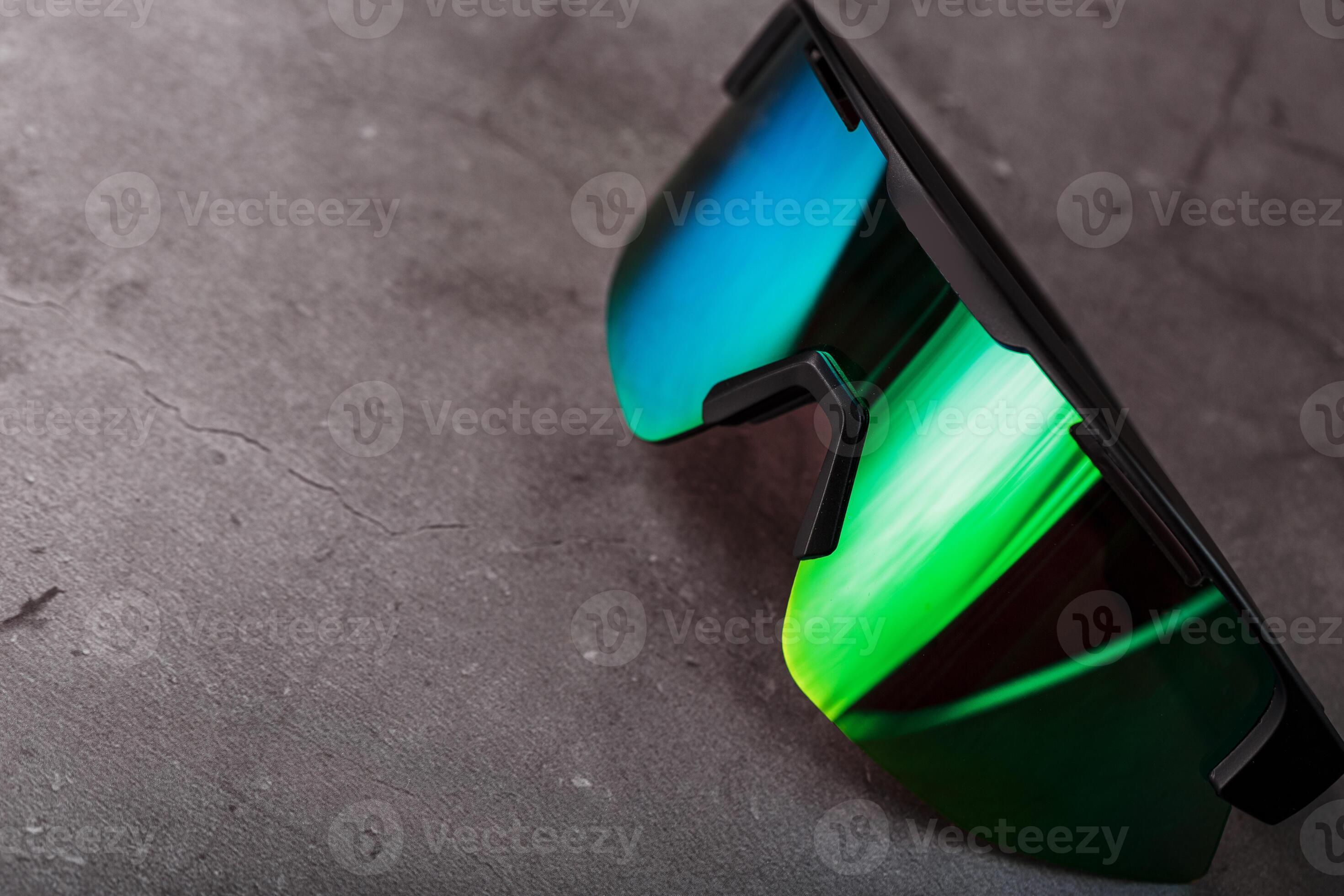 Green sports glasses with a mirror lens on a dark background 12973650