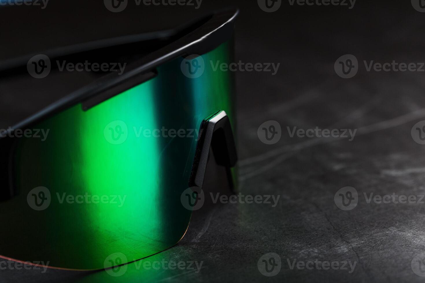 Green sports glasses with a mirror lens on a dark background 12973820