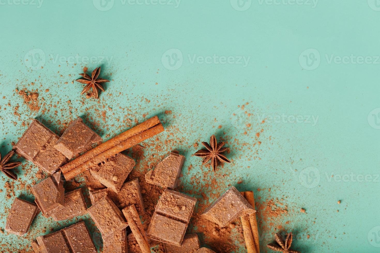 rebanadas de chocolate negro con canela y especias sobre un fondo verde pastel. foto