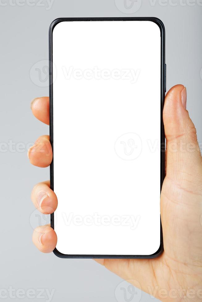 Smartphone with a clean white screen in your hand close-up. photo