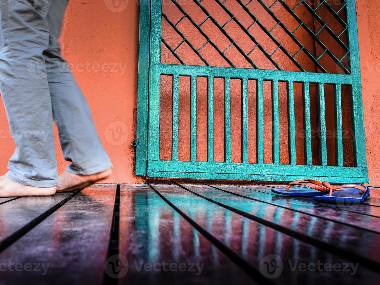 Low angle view of a man walking on a wet boardwalk in Melaka, Malaysia photo