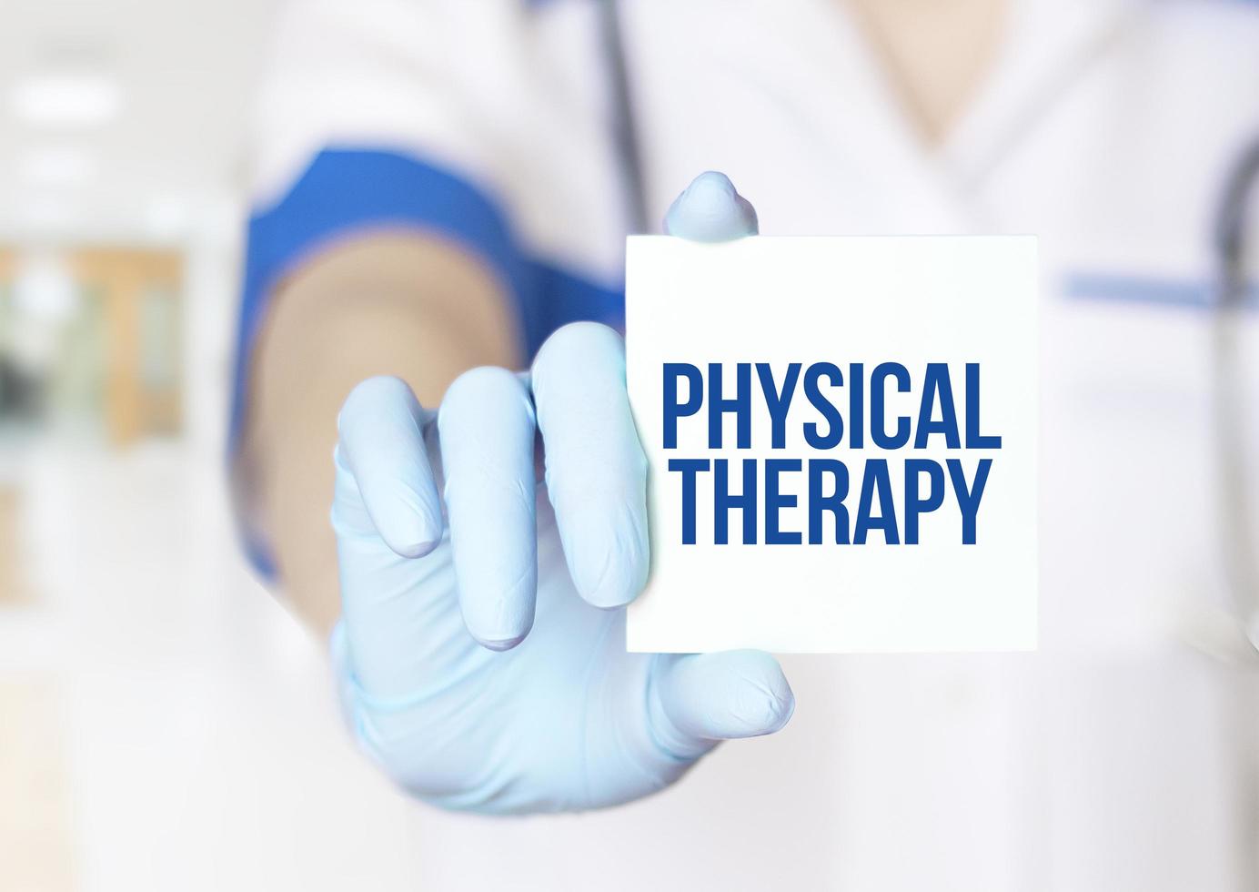 doctor's hand and white sticker with text physical therapy photo