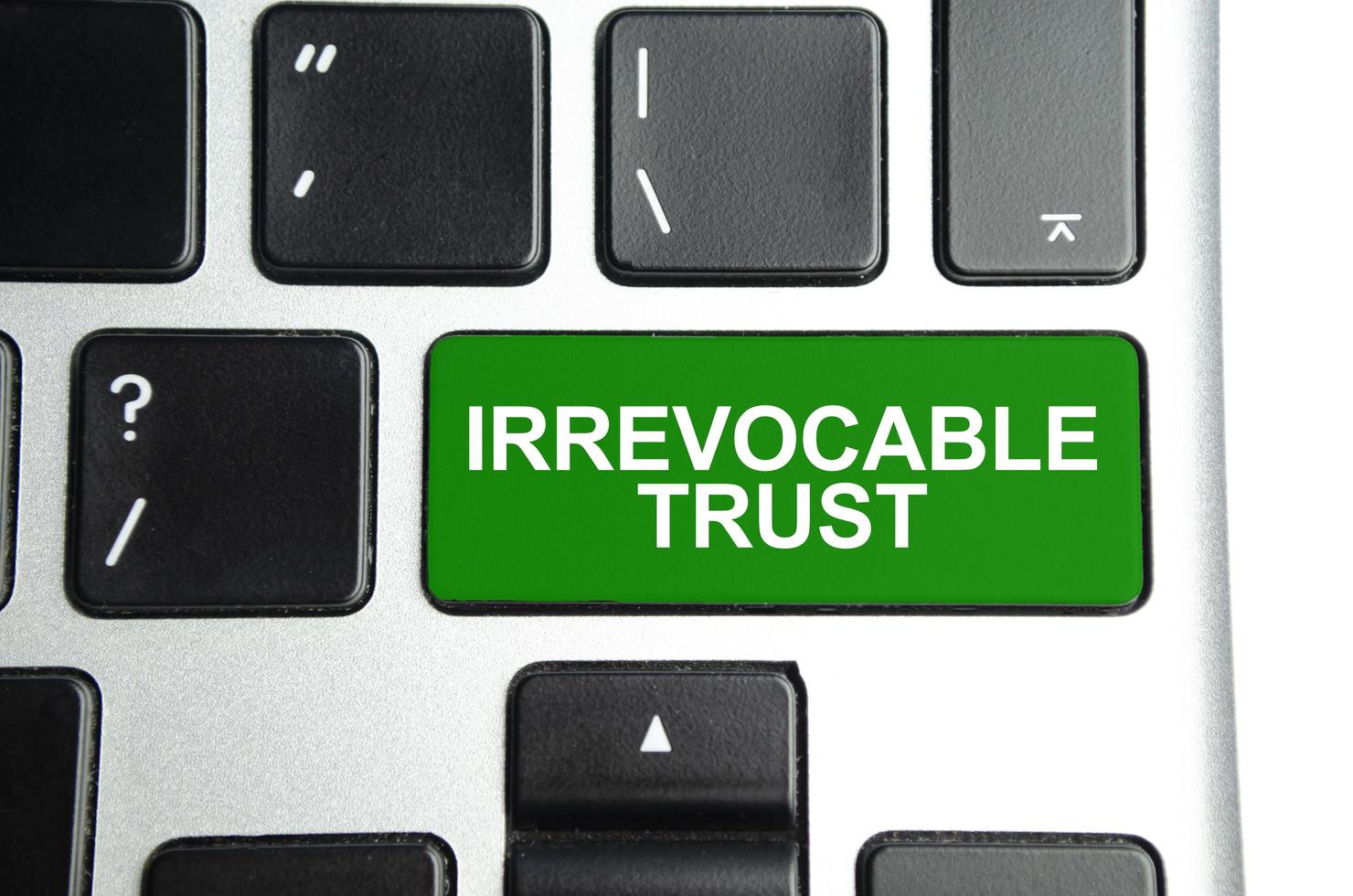 Irrevocable trust text on green button keyboard photo