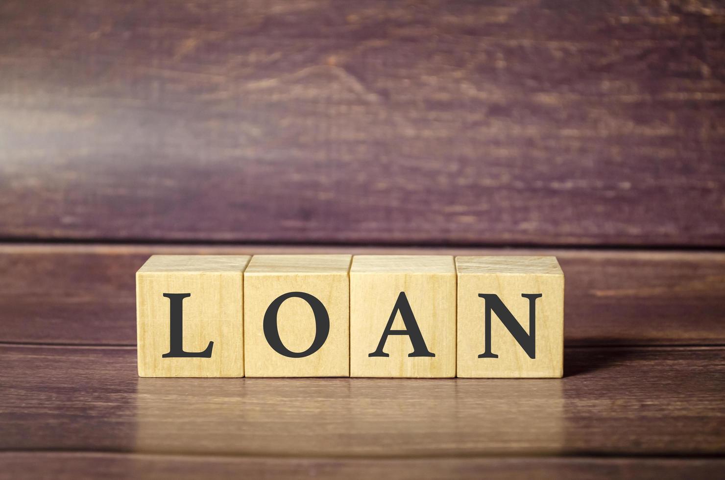 LOAN concept with wooden block on wooden table background. photo