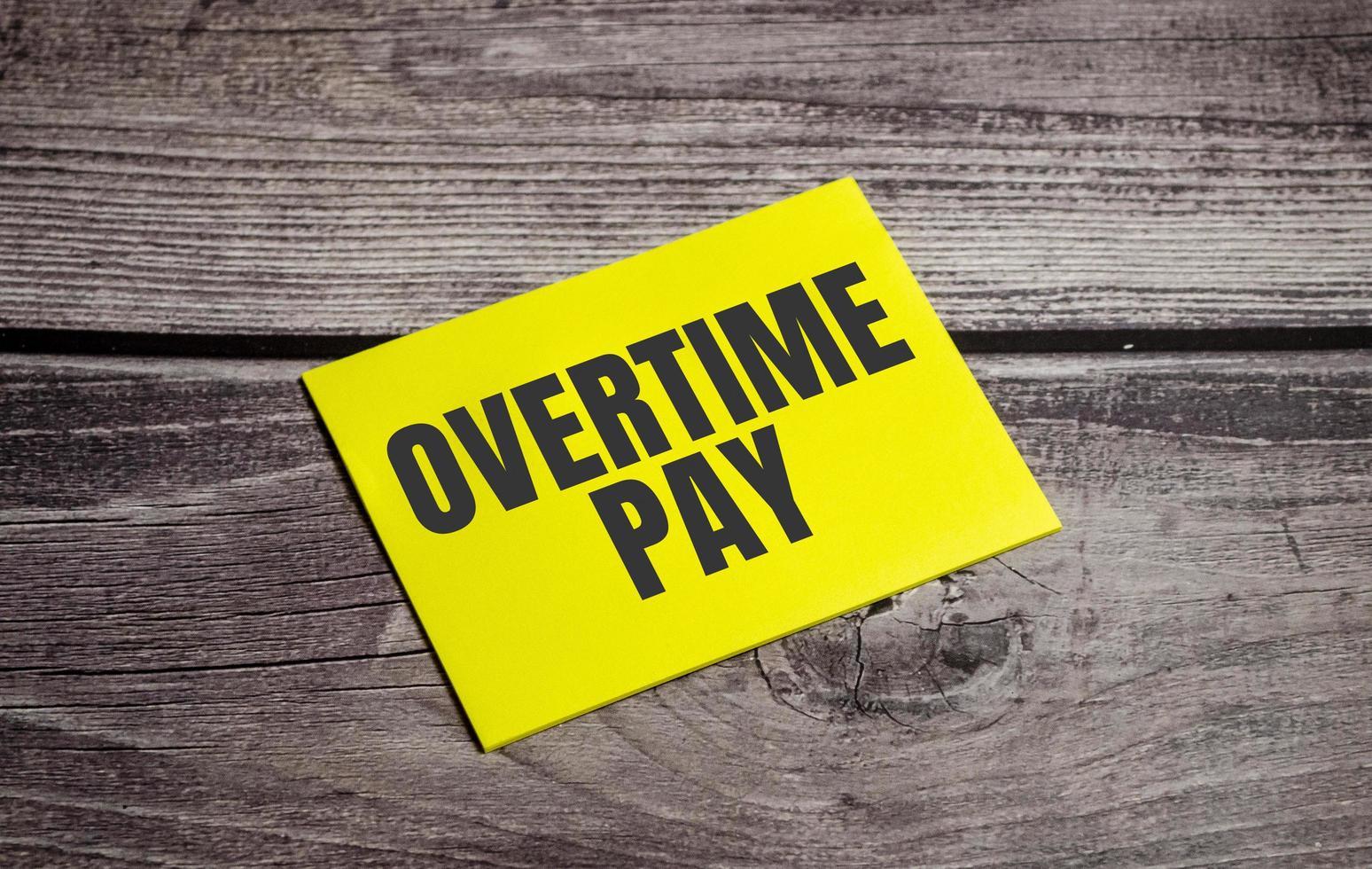 In the yellow sticker the text concept word overtime pay photo