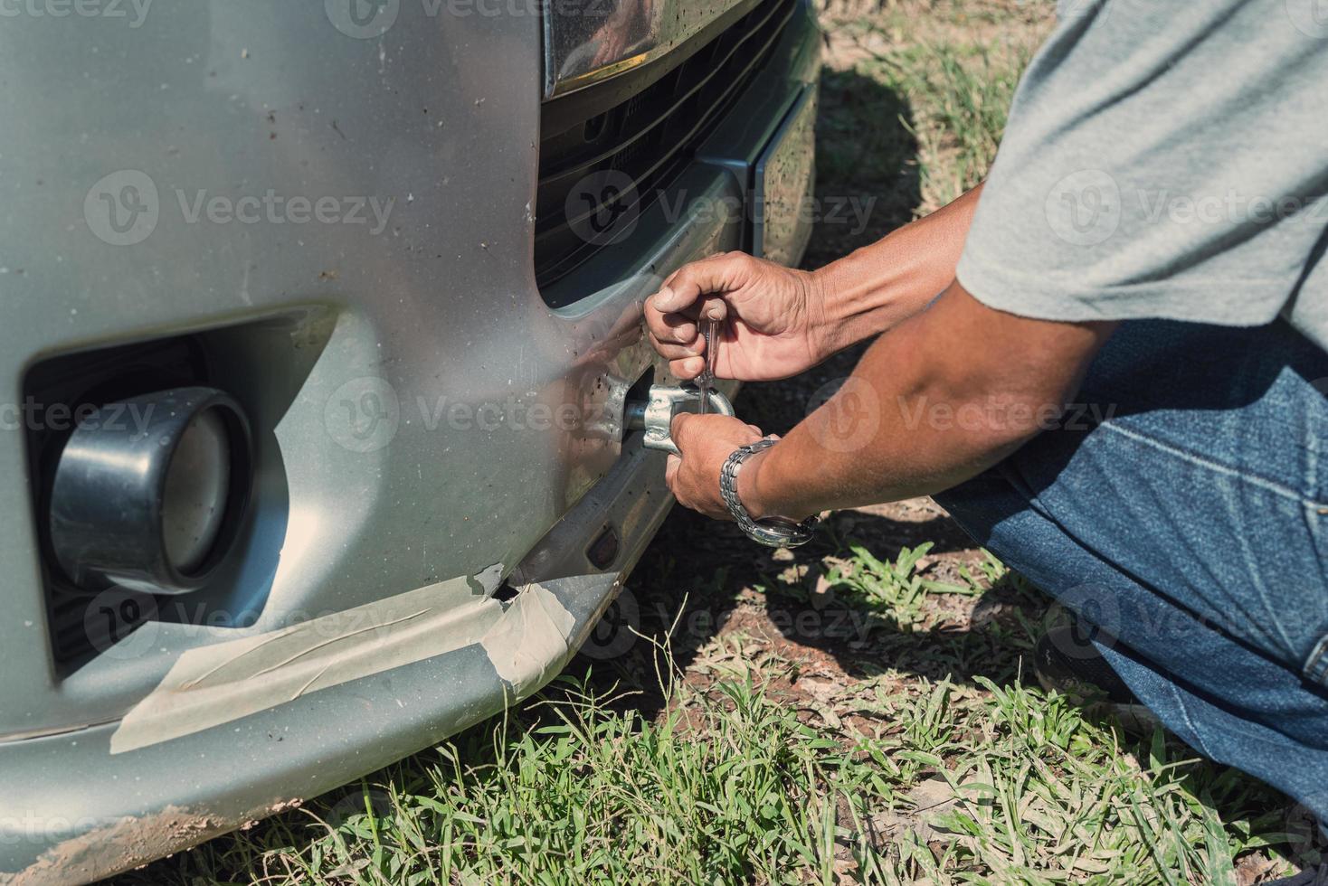 Asian man screws up connection for hauling van. Van crash and park for service. photo