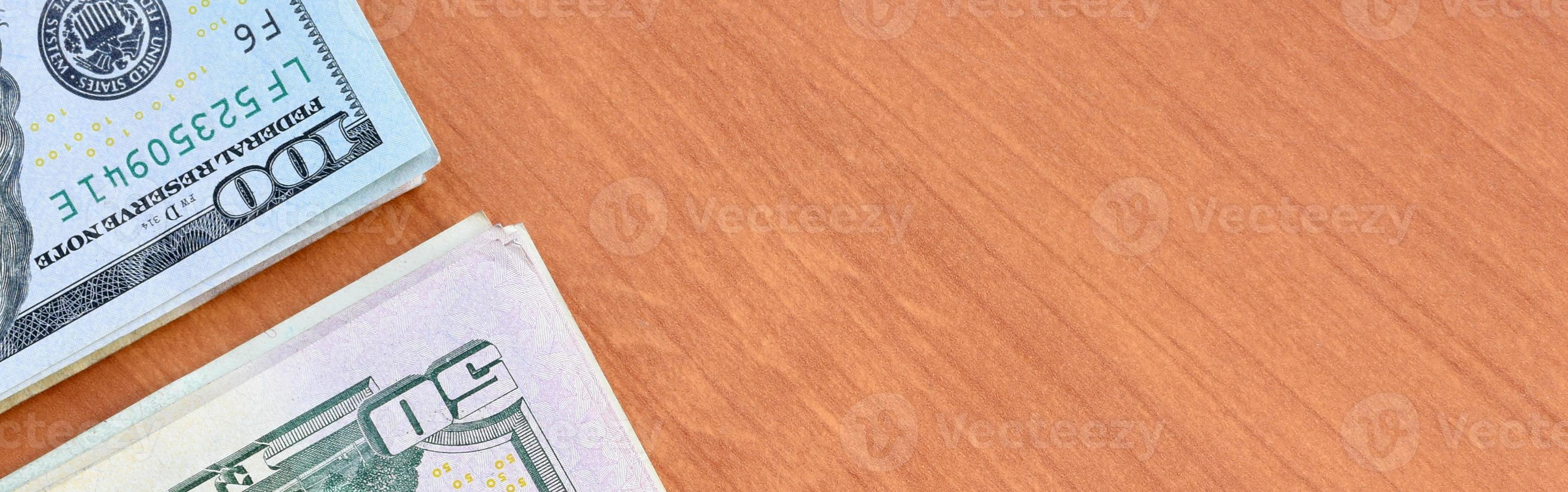 Stacks of many one hundred and fifty dollar bills on wooden background surface close up. Flat lay top view. Abstract business concept photo