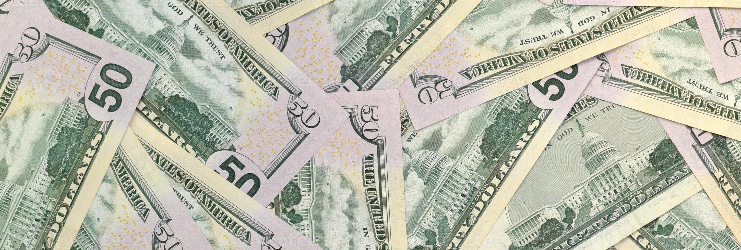 Many US fifty dollar bills on flat background surface close up. Flat lay top view. Abstract business concept photo