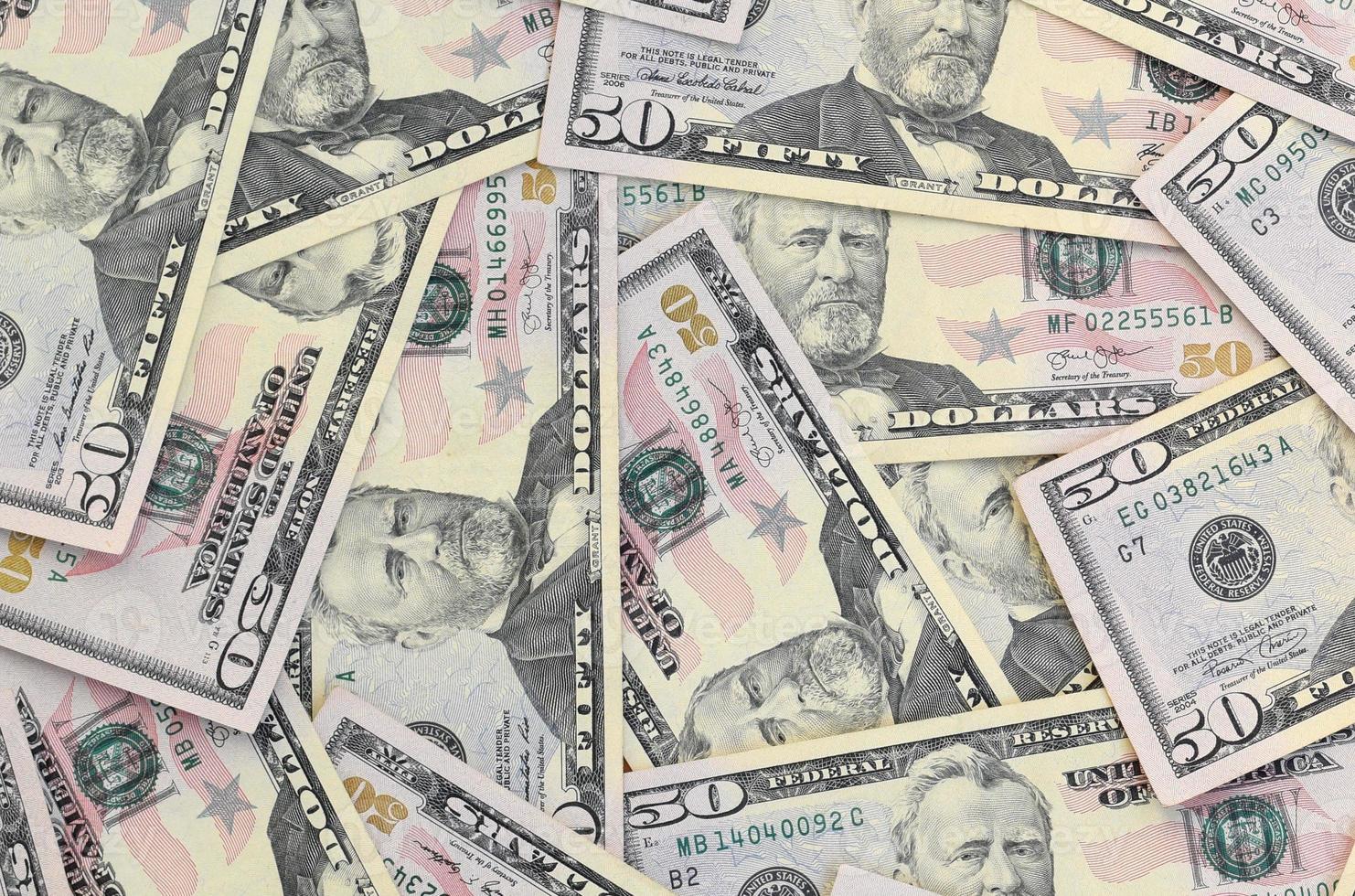 Many US fifty dollar bills on flat background surface close up. Flat lay top view. Abstract business concept photo