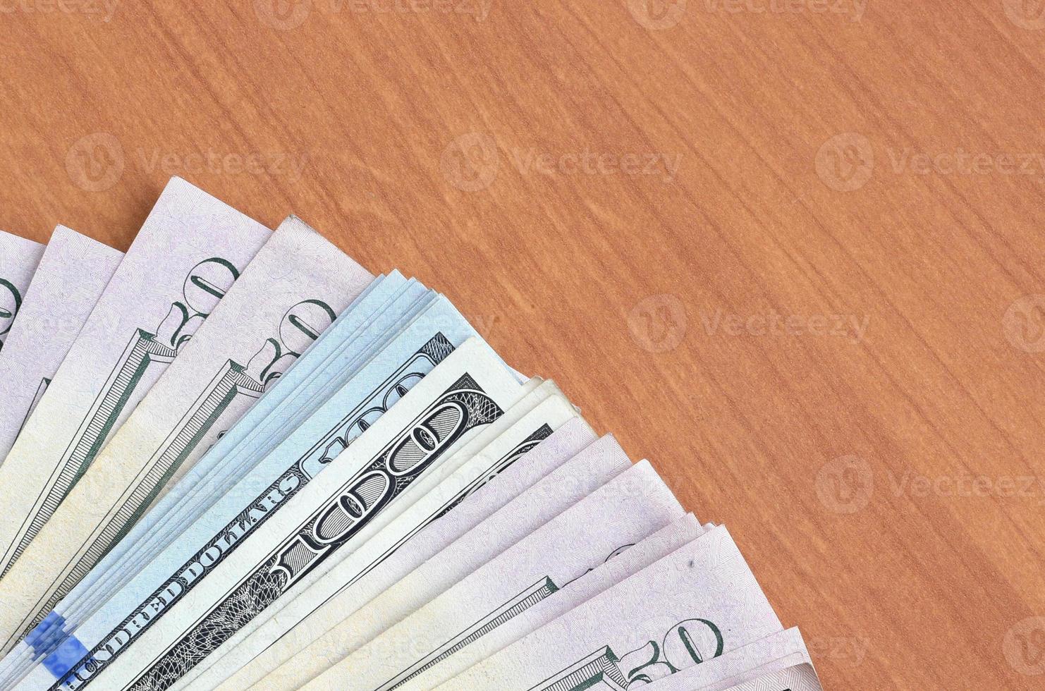 Fan of many one hundred and fifty dollar bills on wooden background surface close up. Flat lay top view. Abstract business concept photo