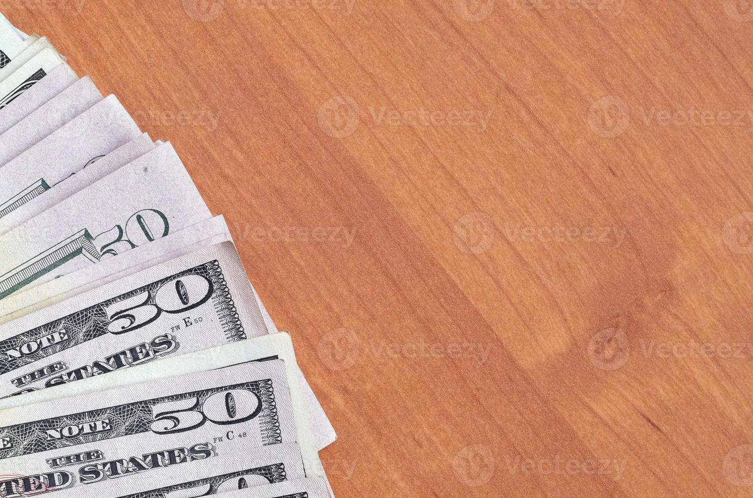 Fan of many one hundred and fifty dollar bills on wooden background surface close up. Flat lay top view. Abstract business concept photo