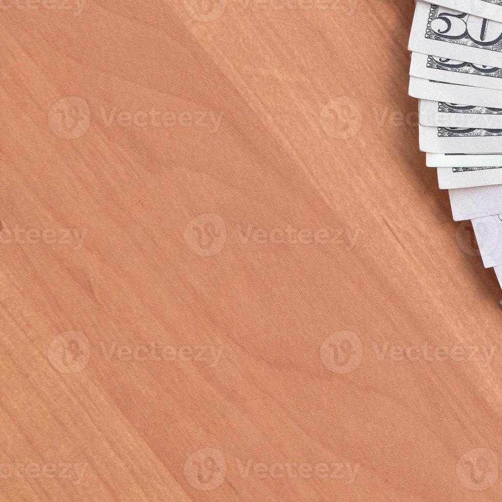 Fan of many one hundred and fifty dollar bills on wooden background surface close up. Flat lay top view. Abstract business concept photo