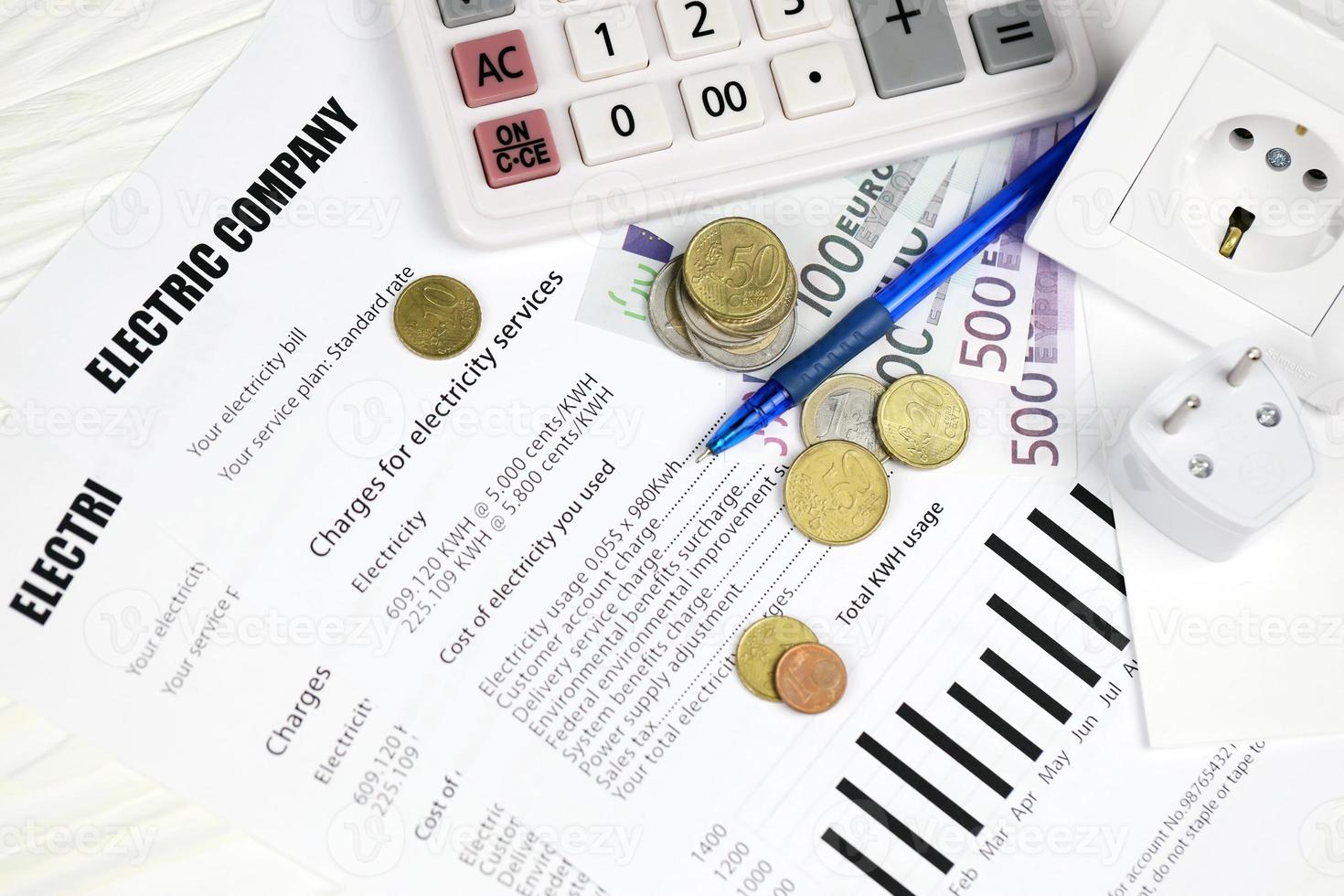 Calculator and Euro bills with pen on european electricity bill. Concept of saving money by using energy savings led light bulbs and electric bill payment photo