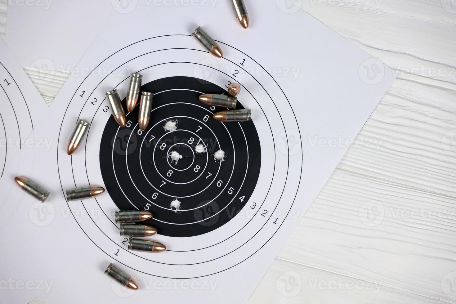 Many bullets on shooting targets on white table in shooting range polygon. Training for aiming and shooting photo