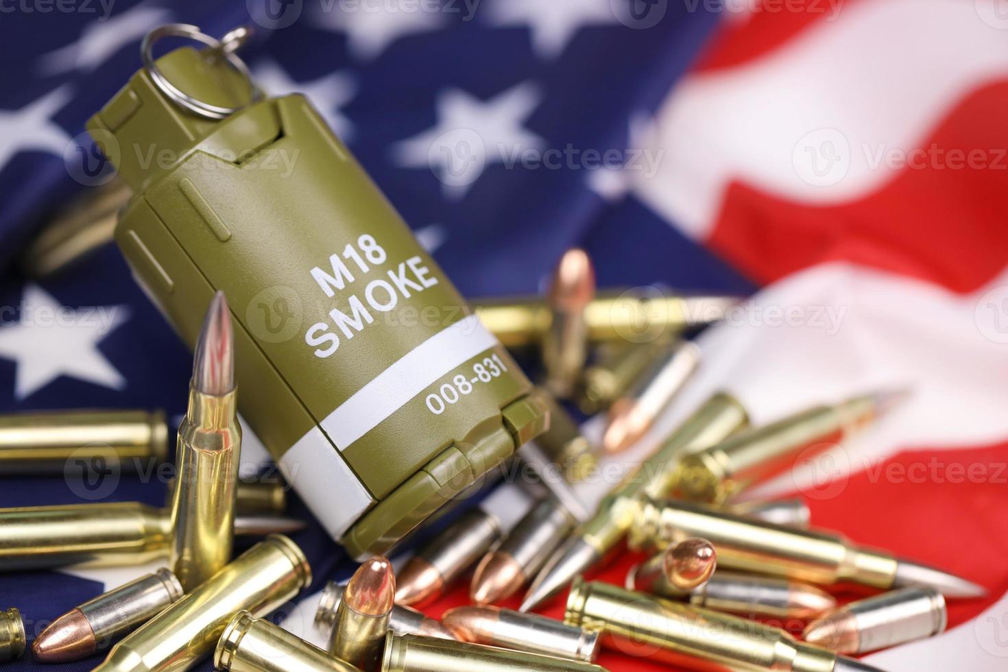 M18 smoke grenade and many yellow bullets and cartridges on United States flag. Concept of gun trafficking on USA territory or spec ops photo
