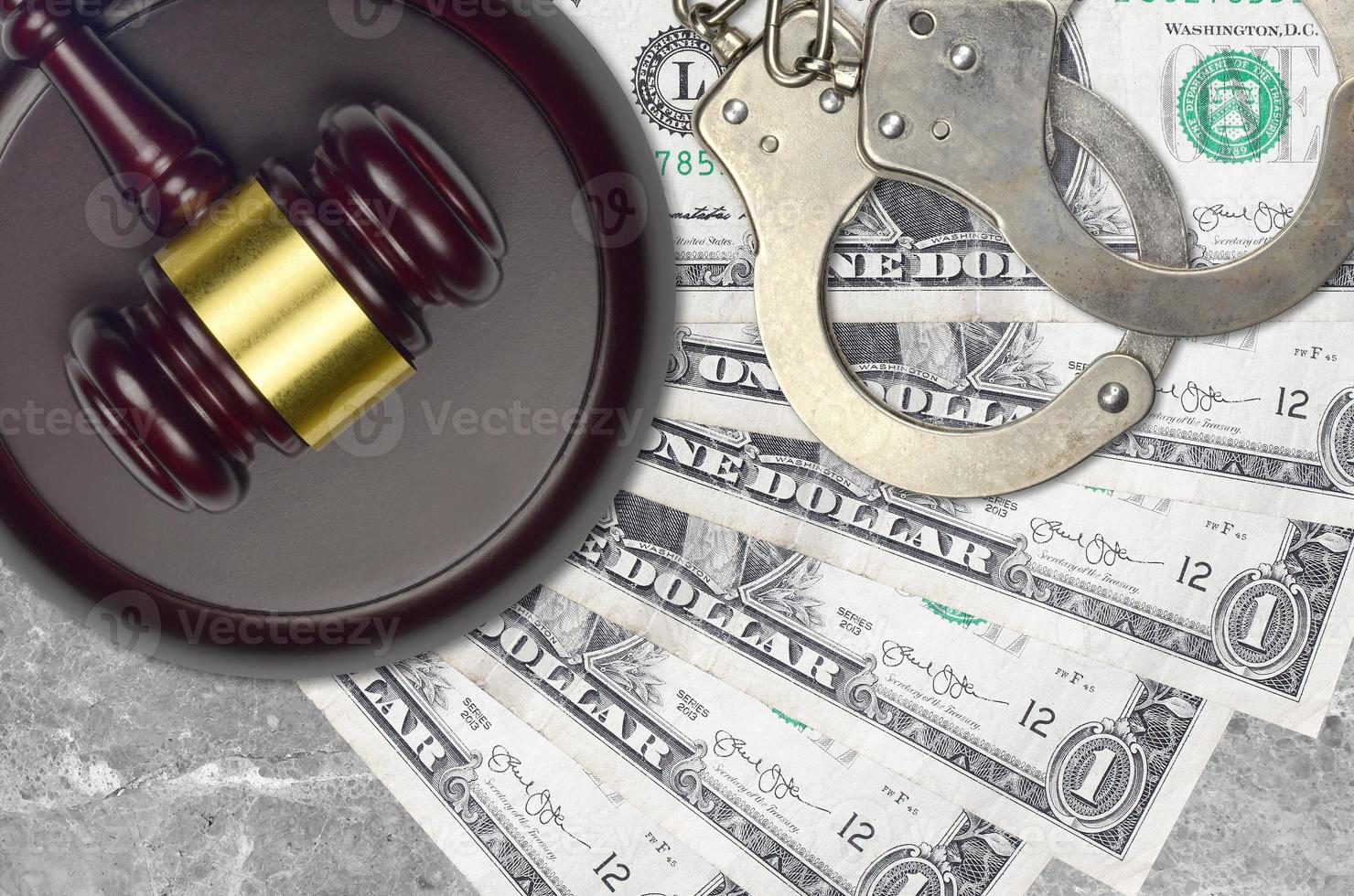 1 US dollar bills and judge hammer with police handcuffs on court desk. Concept of judicial trial or bribery. Tax avoidance photo