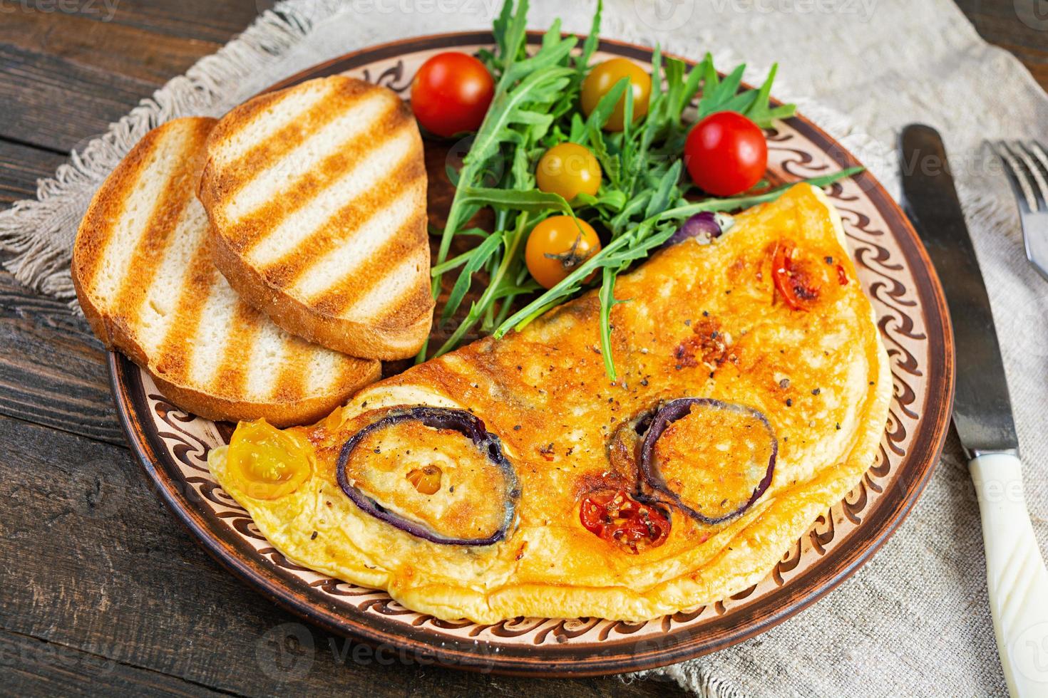 Omelet with tomato, onion, cheese and herbs. Tasty breakfast omelette photo