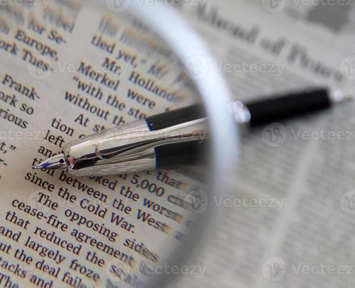 Close up view on international newspapers with a magnifying glass and a soft bokeh photo