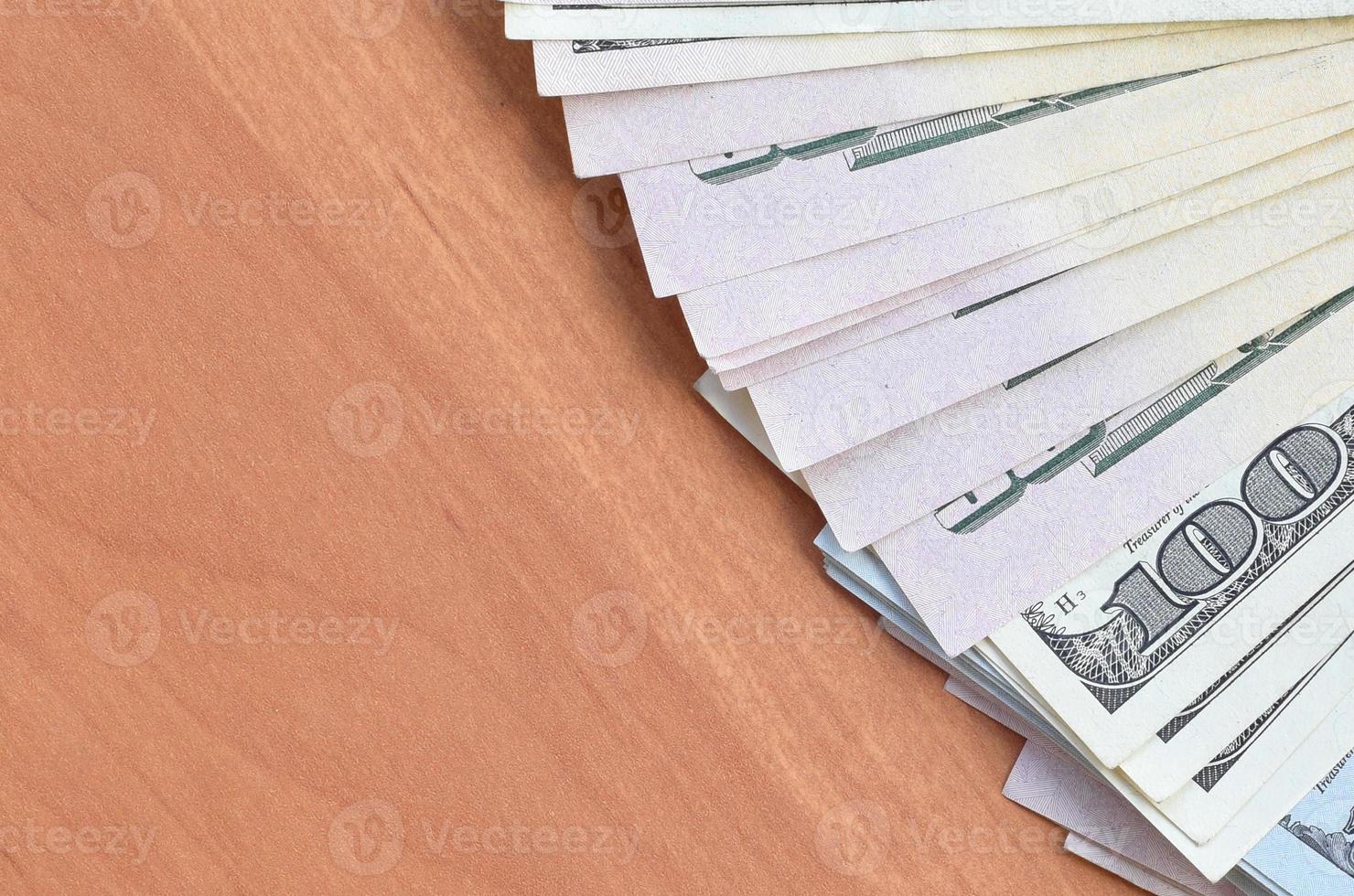 Fan of many one hundred and fifty dollar bills on wooden background surface close up. Flat lay top view. Abstract business concept photo