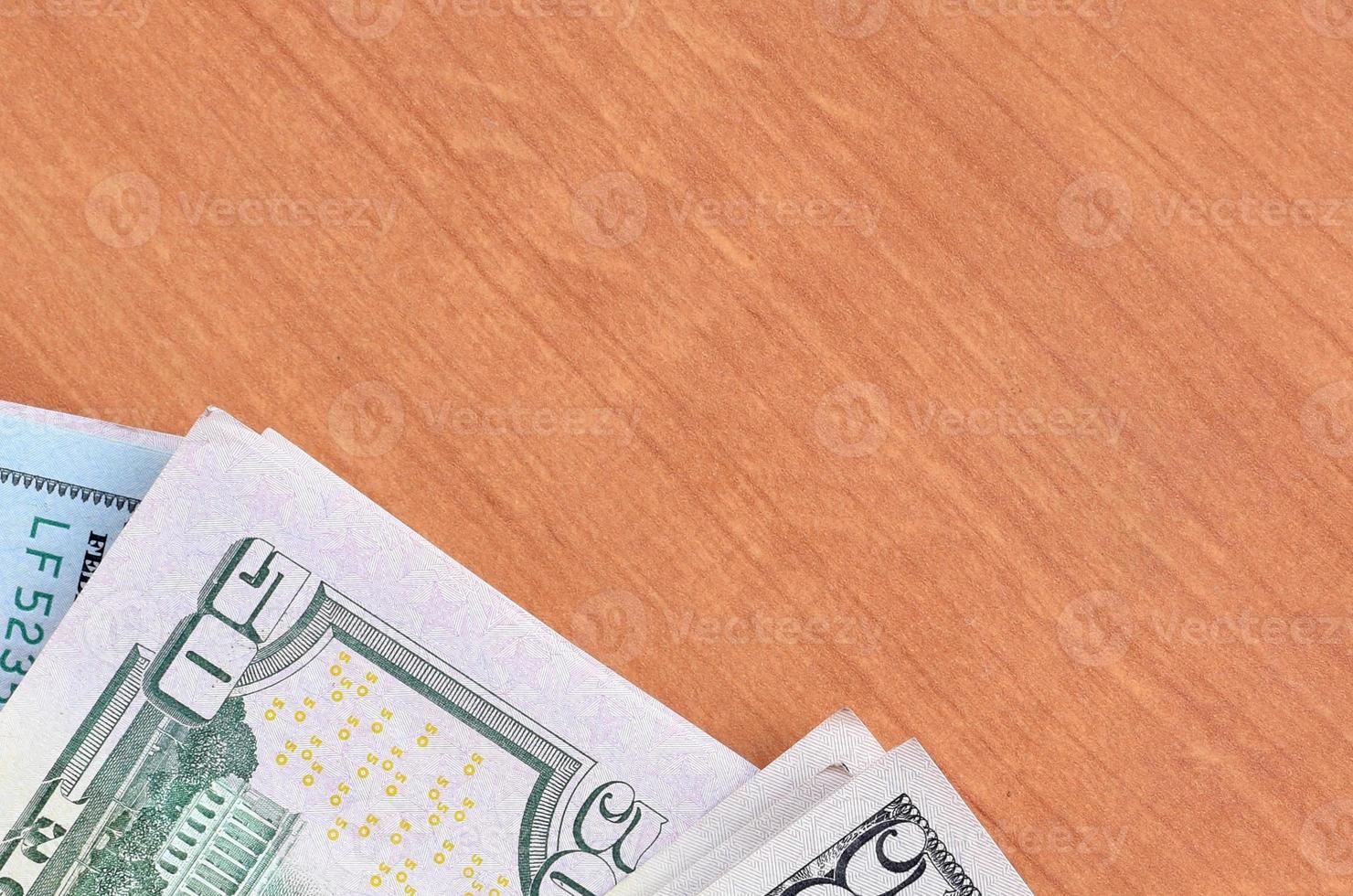 Stacks of many one hundred and fifty dollar bills on wooden background surface close up. Flat lay top view. Abstract business concept photo