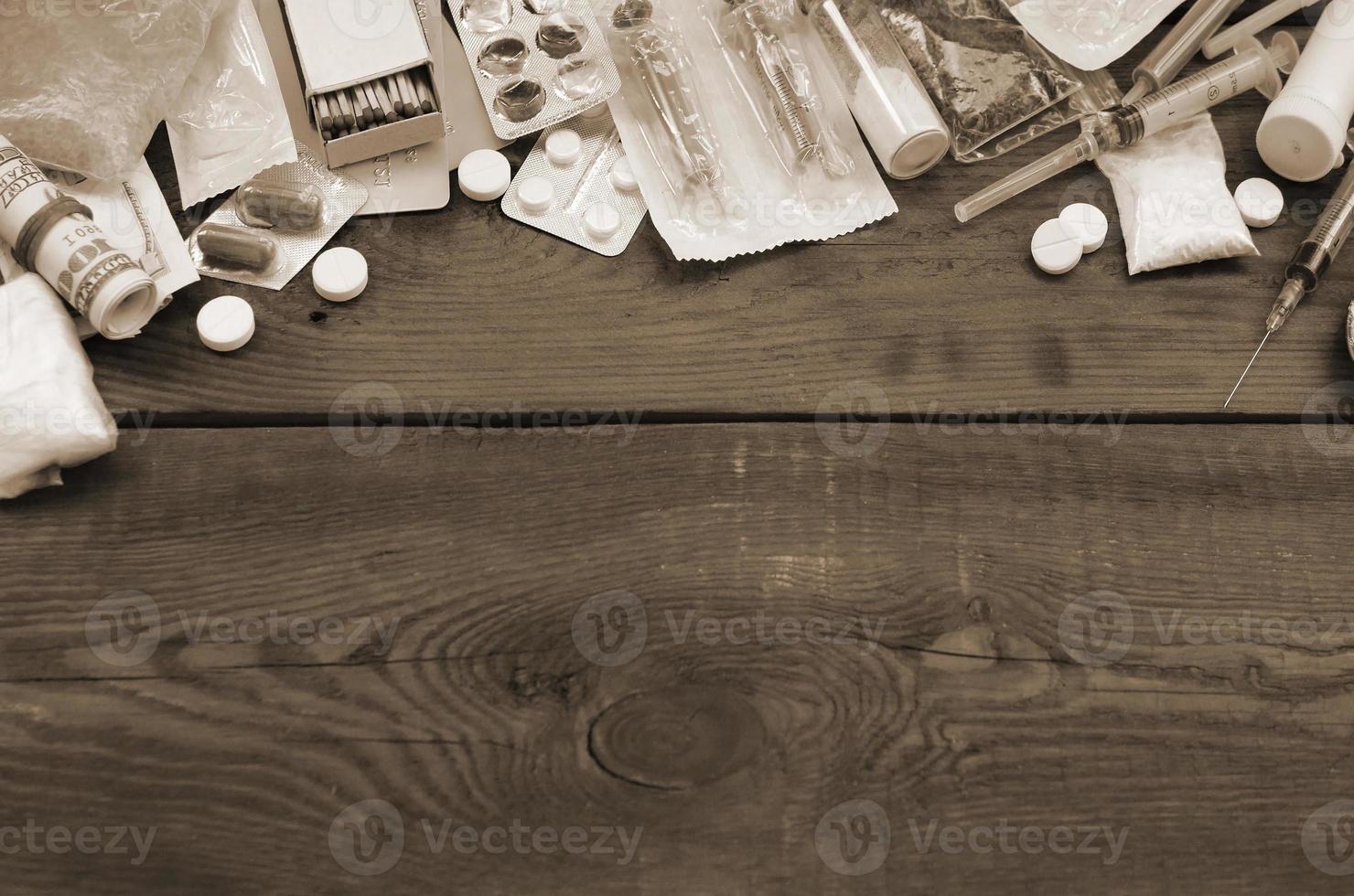 A lot of narcotic substances and devices for the preparation of drugs lie on an old wooden table photo