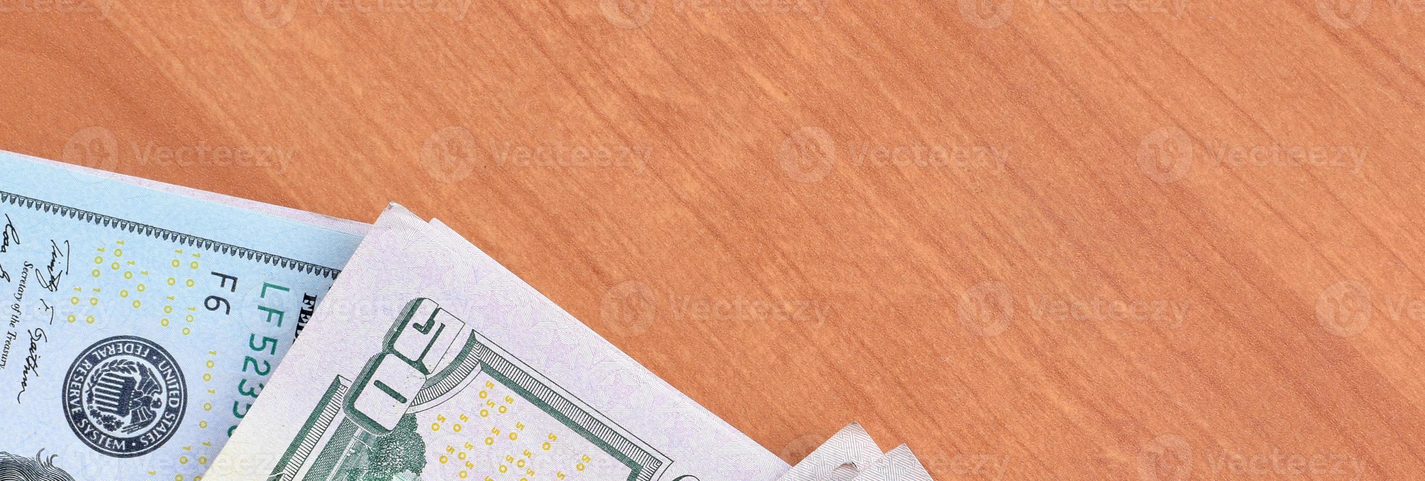 Stacks of many one hundred and fifty dollar bills on wooden background surface close up. Flat lay top view. Abstract business concept photo