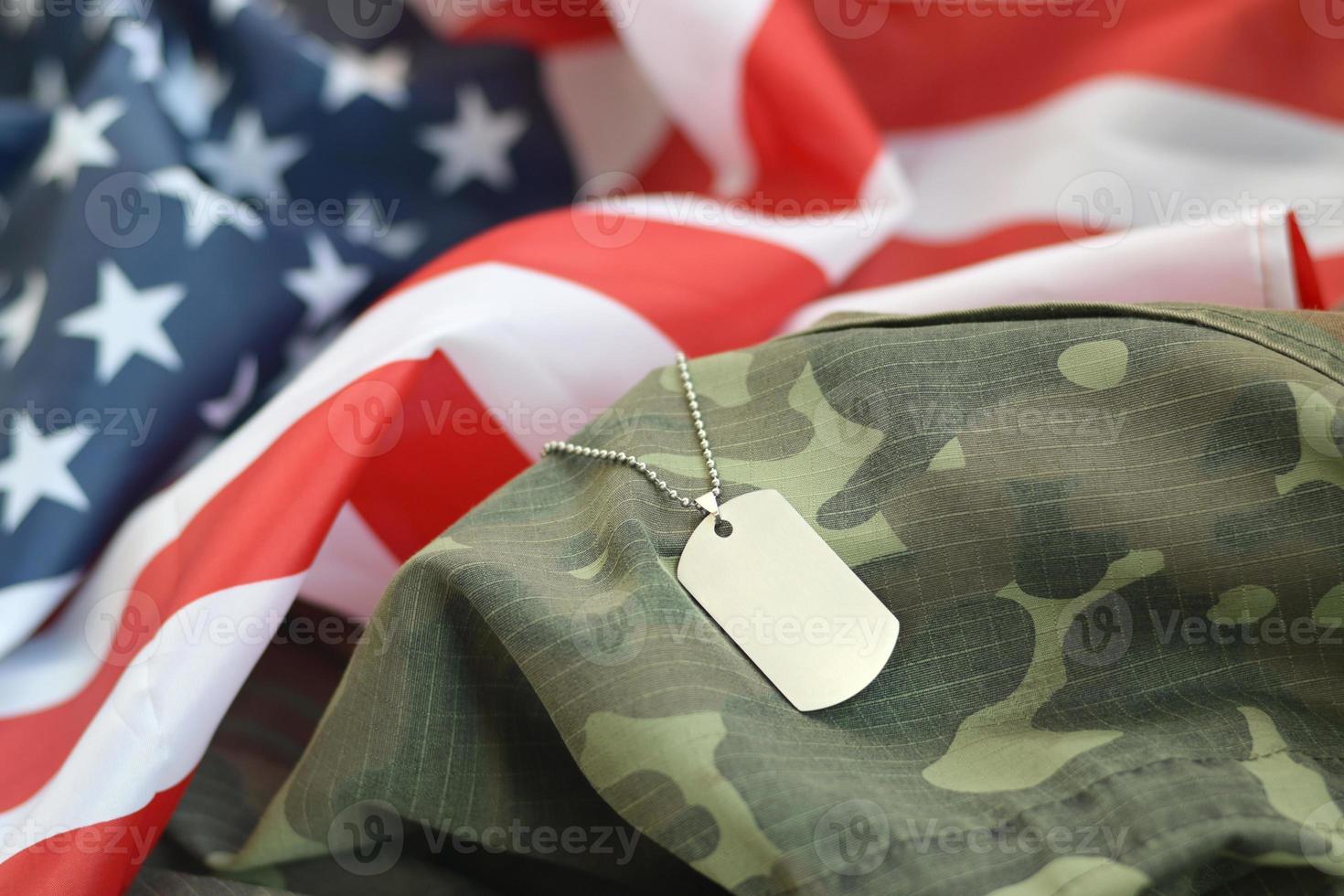 Cuentas militares plateadas con etiqueta de perro en la bandera de tela de los Estados Unidos y uniforme de camuflaje foto