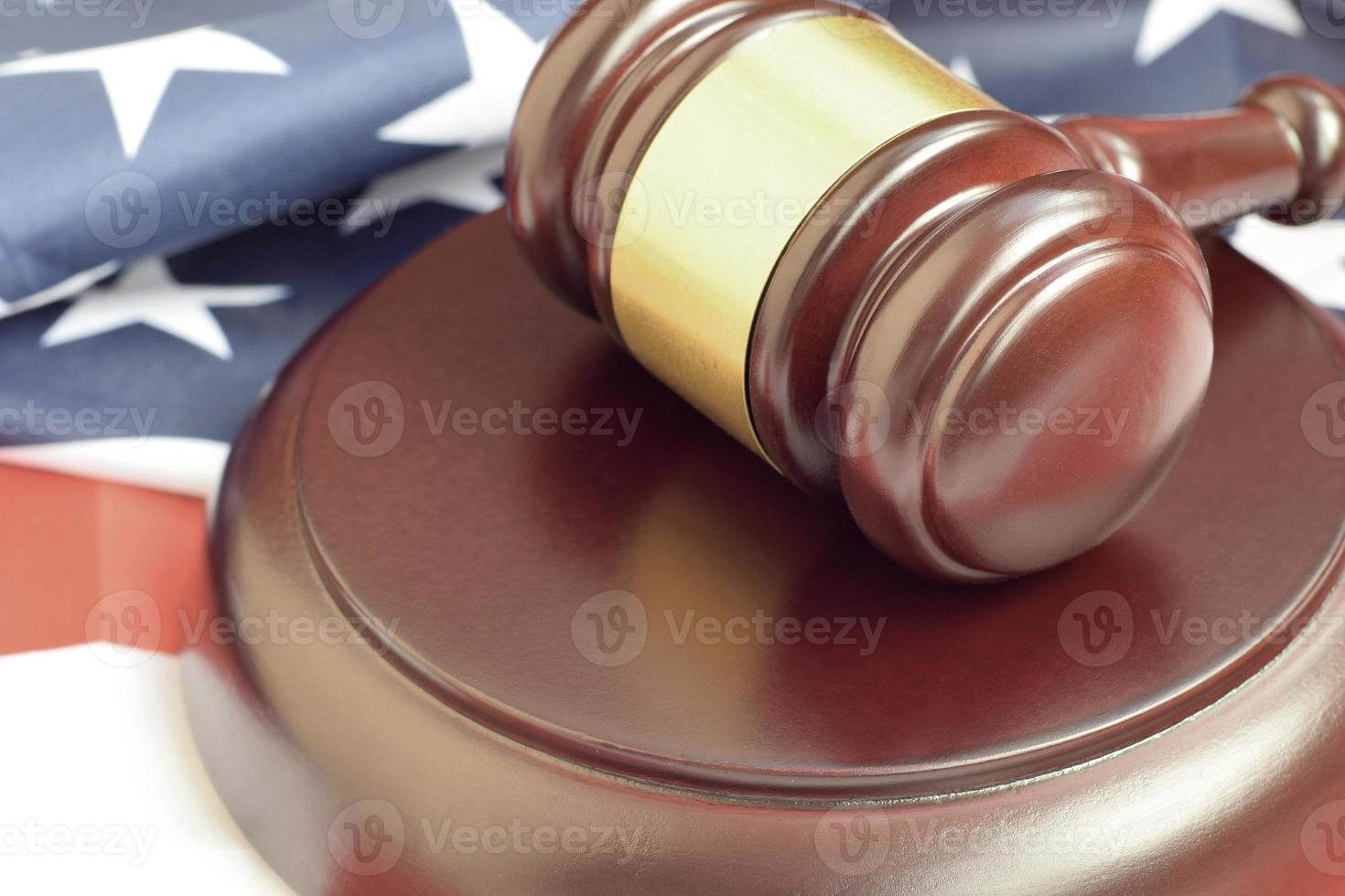 Justice mallet on United States flag in a courtroom during a judicial trial. Law concept and empty copyspace. Judge hammer photo