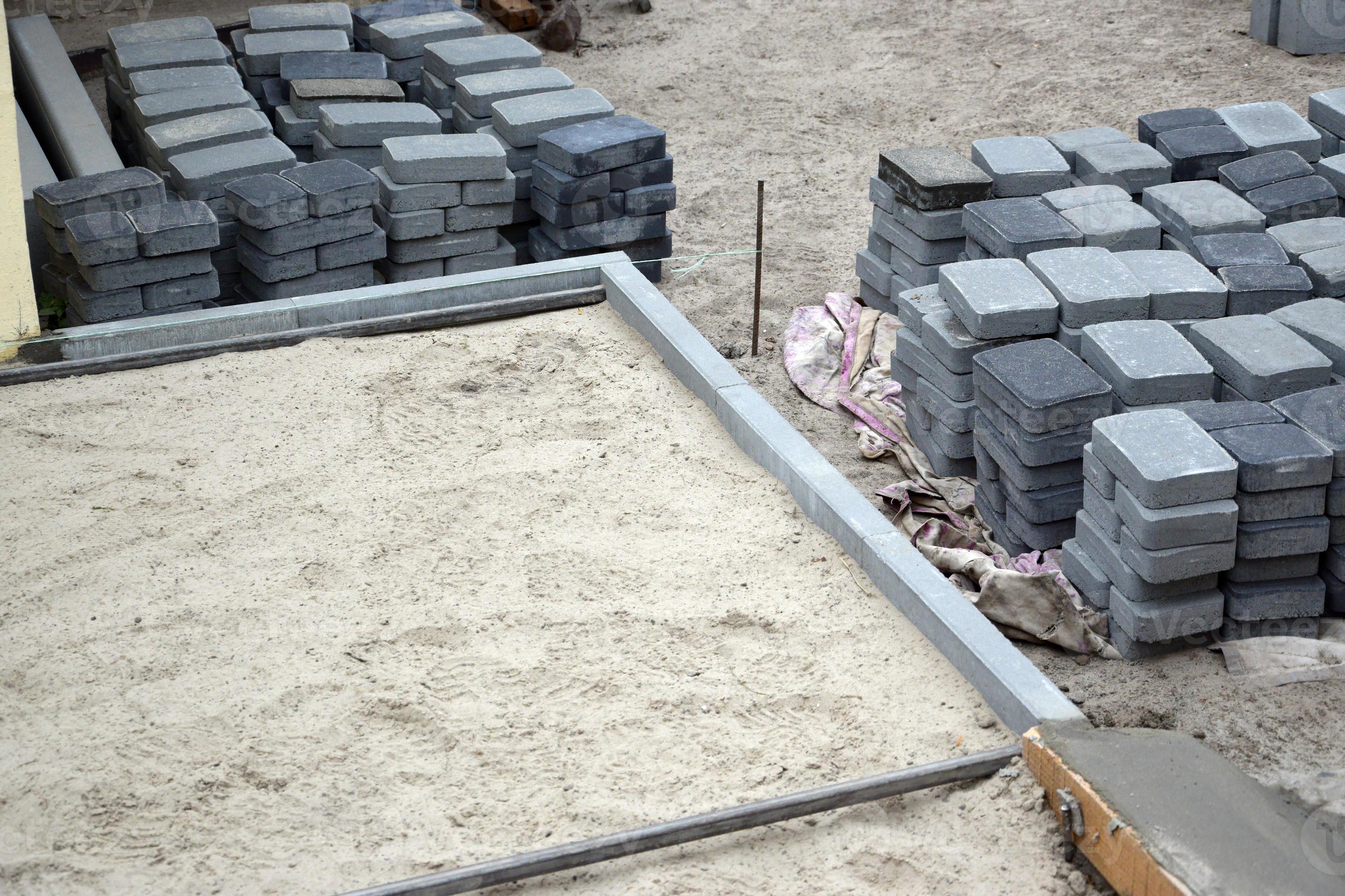 Rows of gray and dark grey walkway slab lying outdoors. Material for