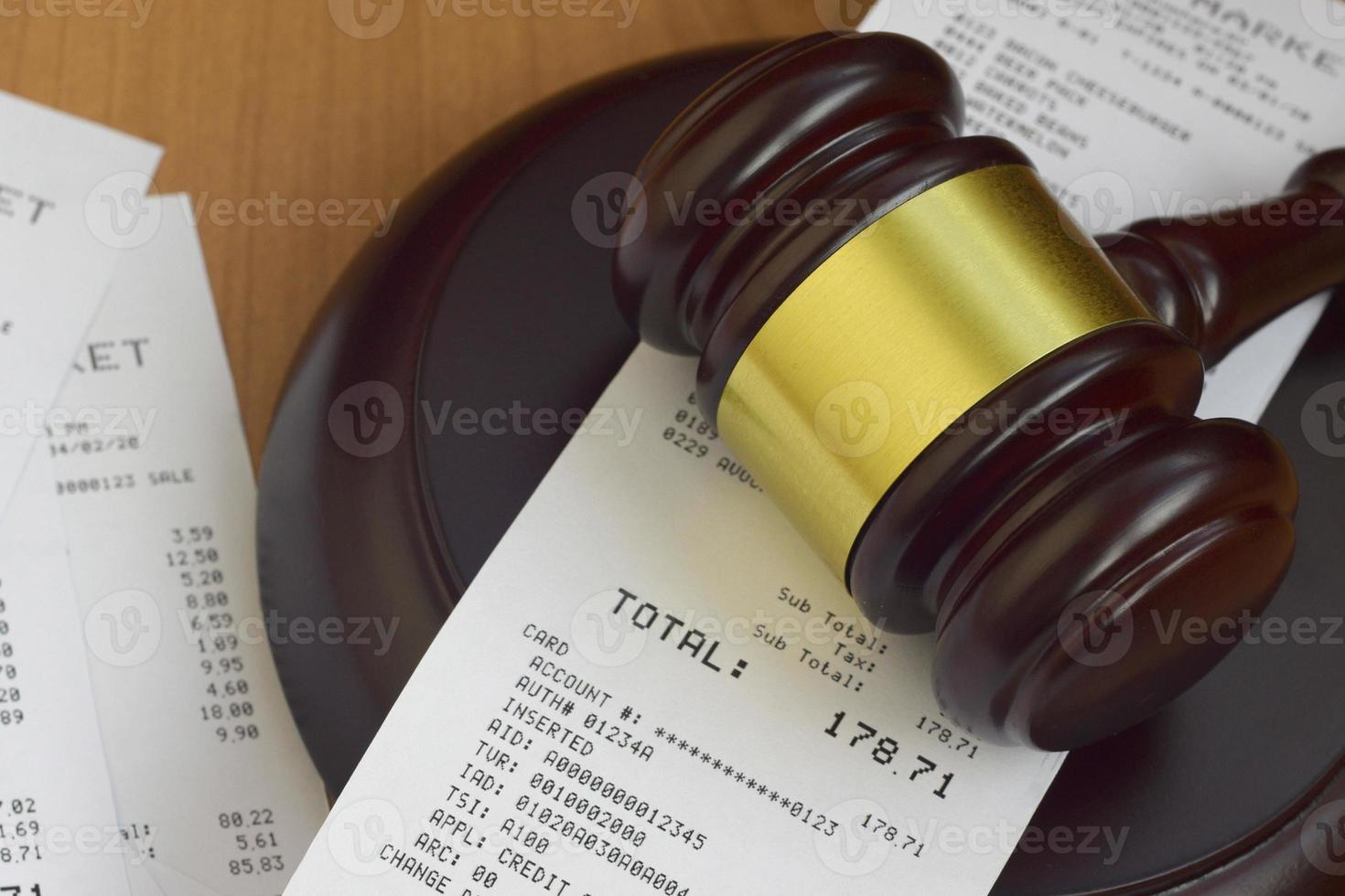 Justice mallet and many supermarket receipts on wooden table photo