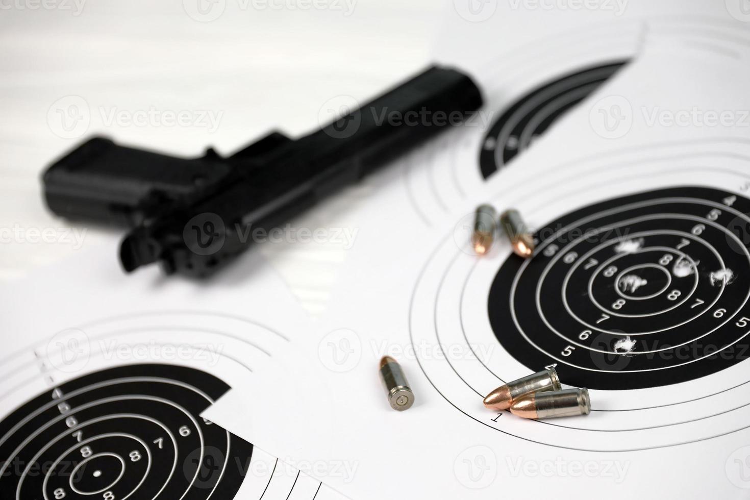 Gun and many bullets shooting targets on white table in shooting range polygon. Training for aiming and shooting photo