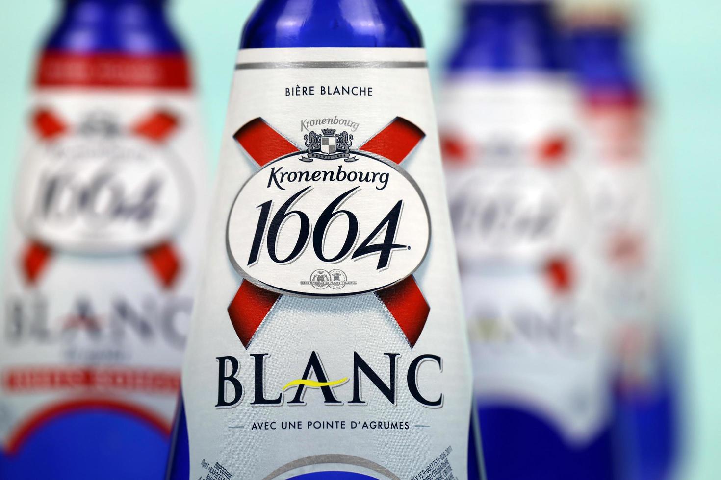 KHARKOV, UKRAINE - DECEMBER 8, 2020 Blanc logo on beer bottles on white table. 1664 Blanc is the wheat beer from French brewery Kronenbourg exported worldwide photo