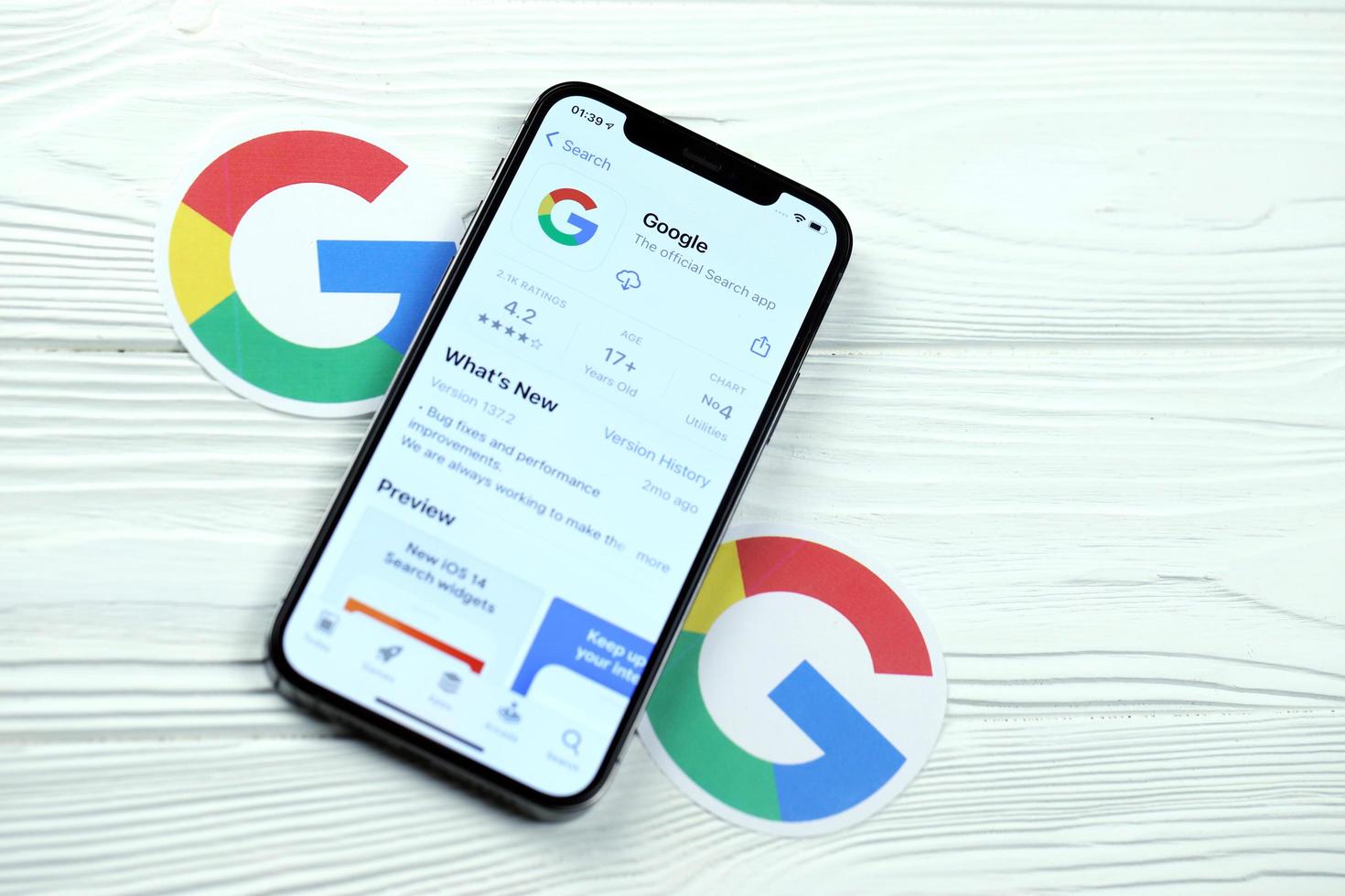 KHARKOV, UKRAINE - MARCH 5, 2021 Google icon and application from App store on iPhone 12 pro display screen on white table photo