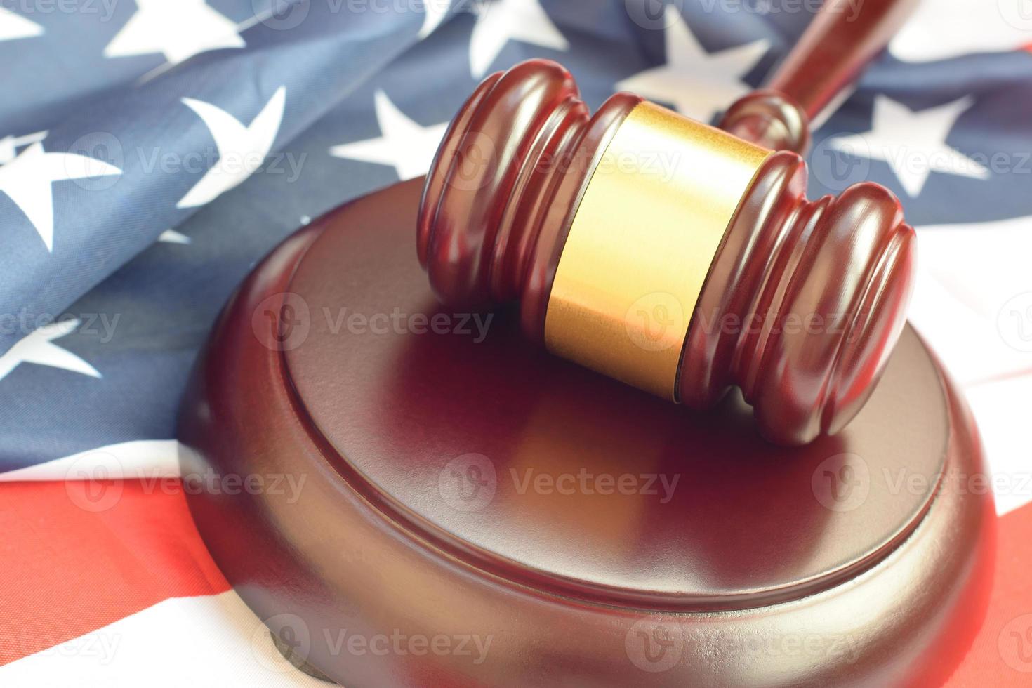 Mazo de justicia en la bandera de los Estados Unidos en una sala de audiencias durante un juicio judicial. concepto de ley y copyspace vacío. juez martillo foto