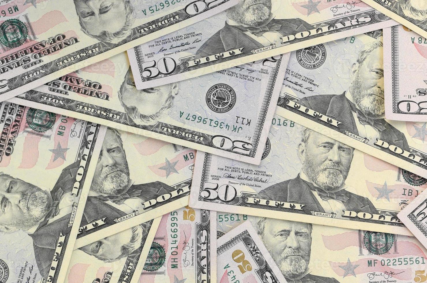 Many US fifty dollar bills on flat background surface close up. Flat lay top view. Abstract business concept photo