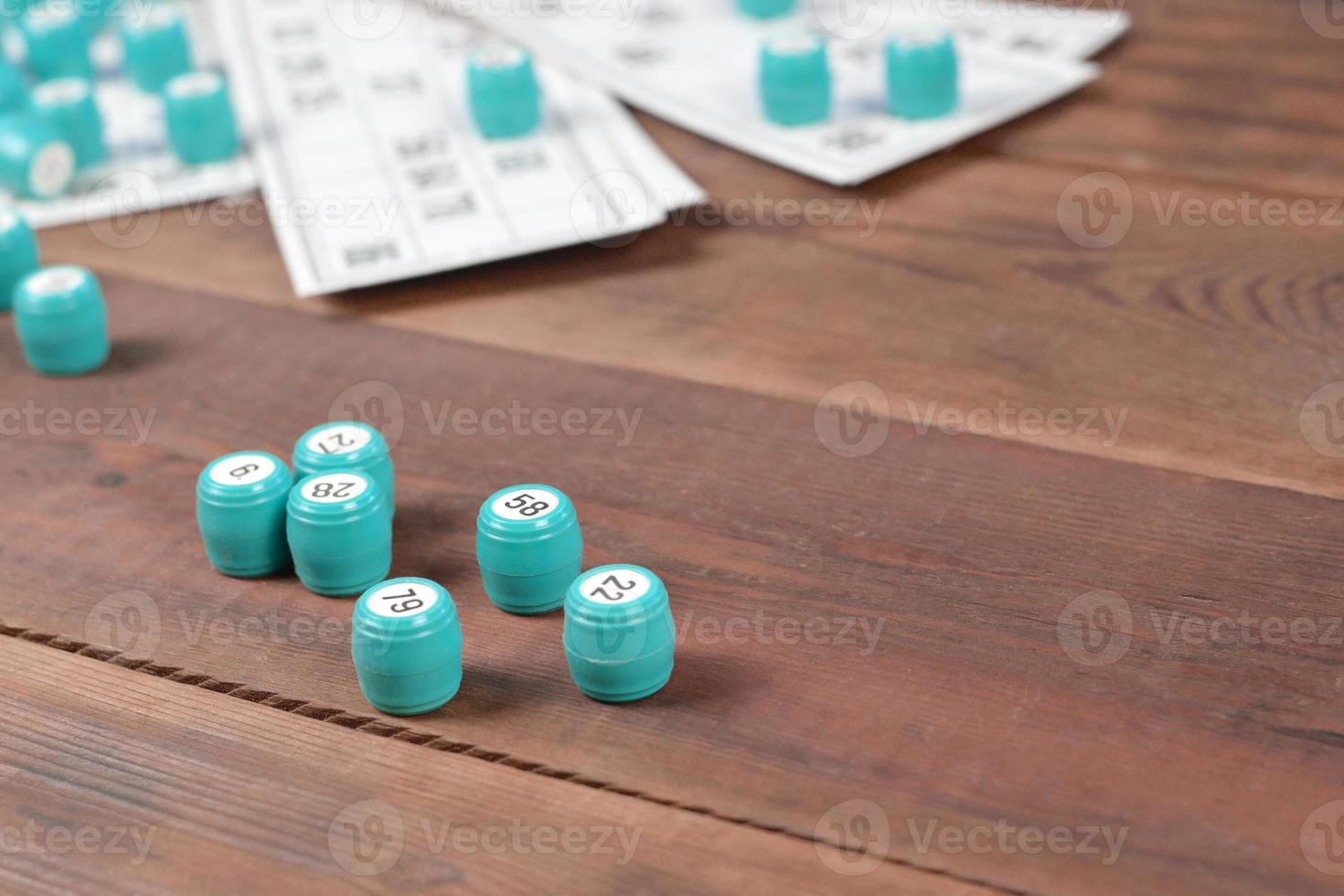 Many barrels with numbers and cards for lotto or russian bingo table game on wooden surface. Russian lotto has similar rules to classical worldwide bingo photo