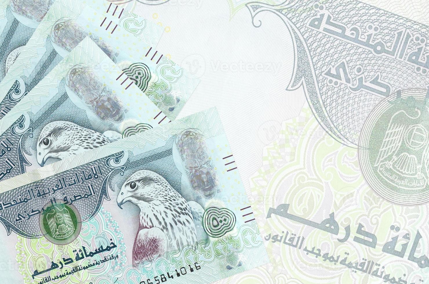 500 UAE dirhams bills lies in stack on background of big semi-transparent banknote. Abstract business background photo