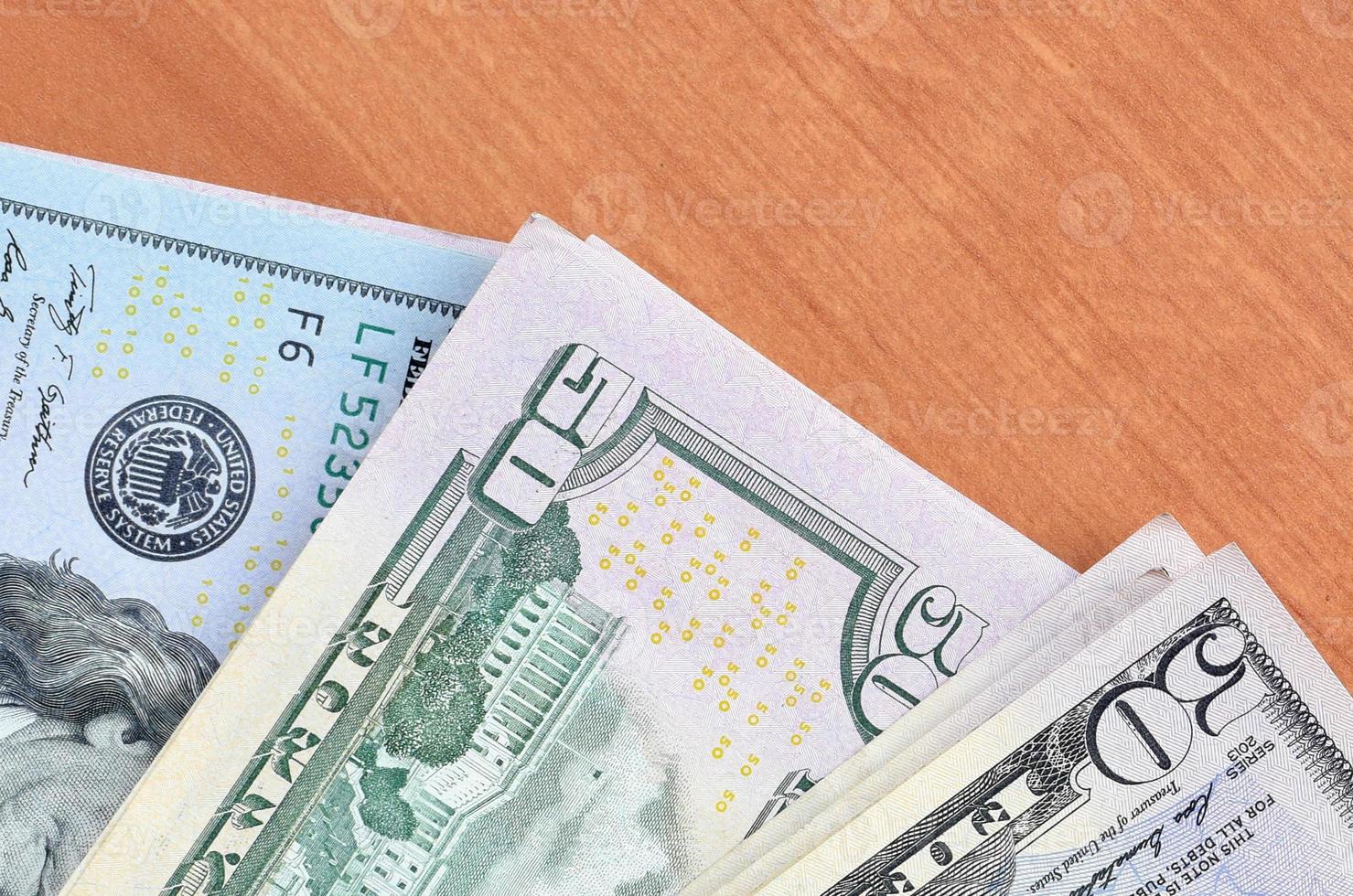 Stacks of many one hundred and fifty dollar bills on wooden background surface close up. Flat lay top view. Abstract business concept photo