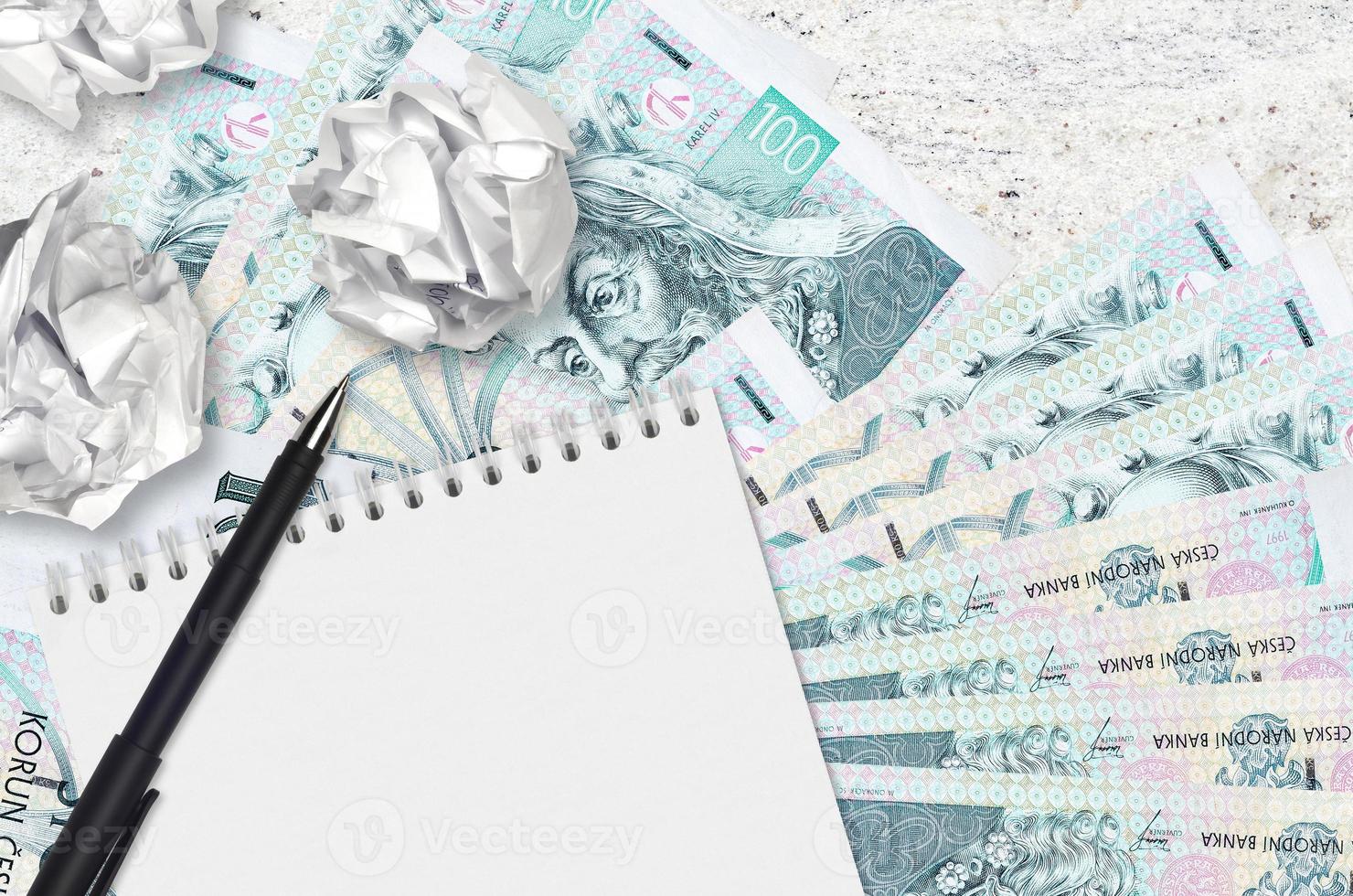 100 billetes de korun checo y bolas de papel arrugado con bloc de notas en blanco. malas ideas o menos concepto de inspiración. buscando ideas de inversión foto