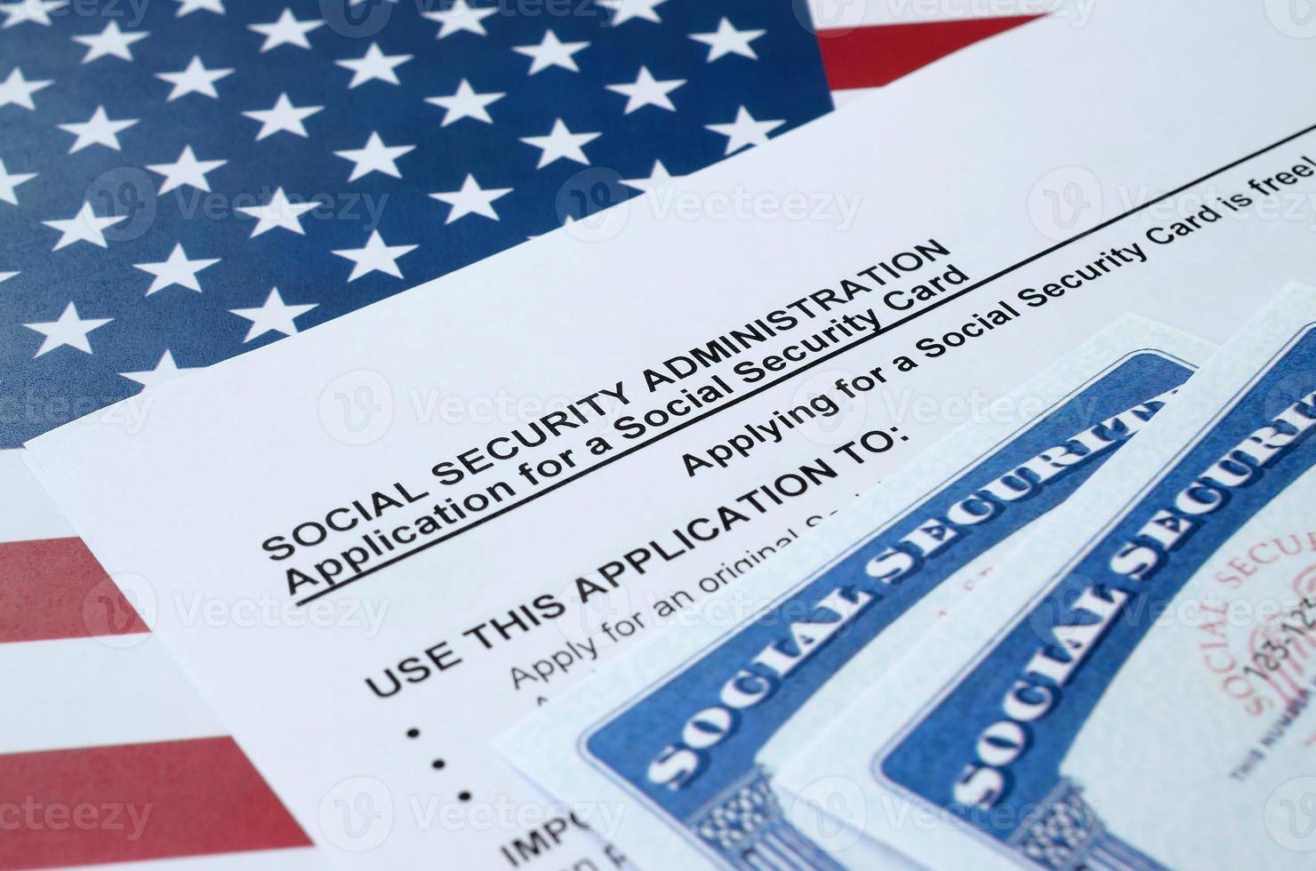 United States social security number cards lies on Application from social security administration on US flag photo