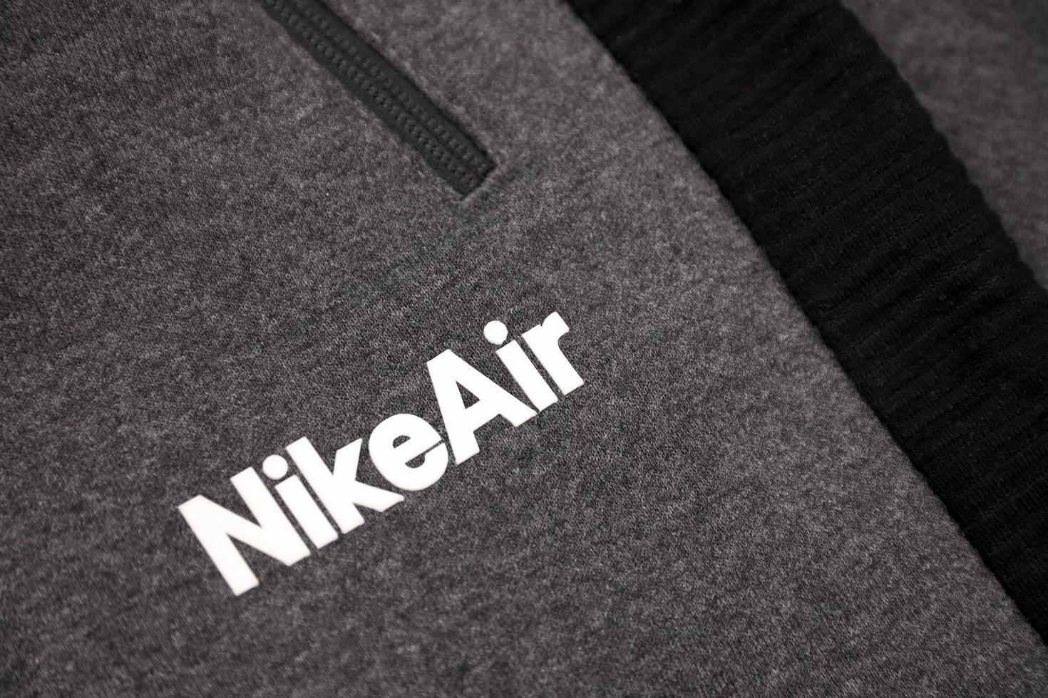 KHARKOV, UKRAINE - DECEMBER 20, 2020 Nike air logo on grey sports wear fragment. Nike is American multinational corporation engaged in manufacturing and worldwide marketing of clothes and footwear photo
