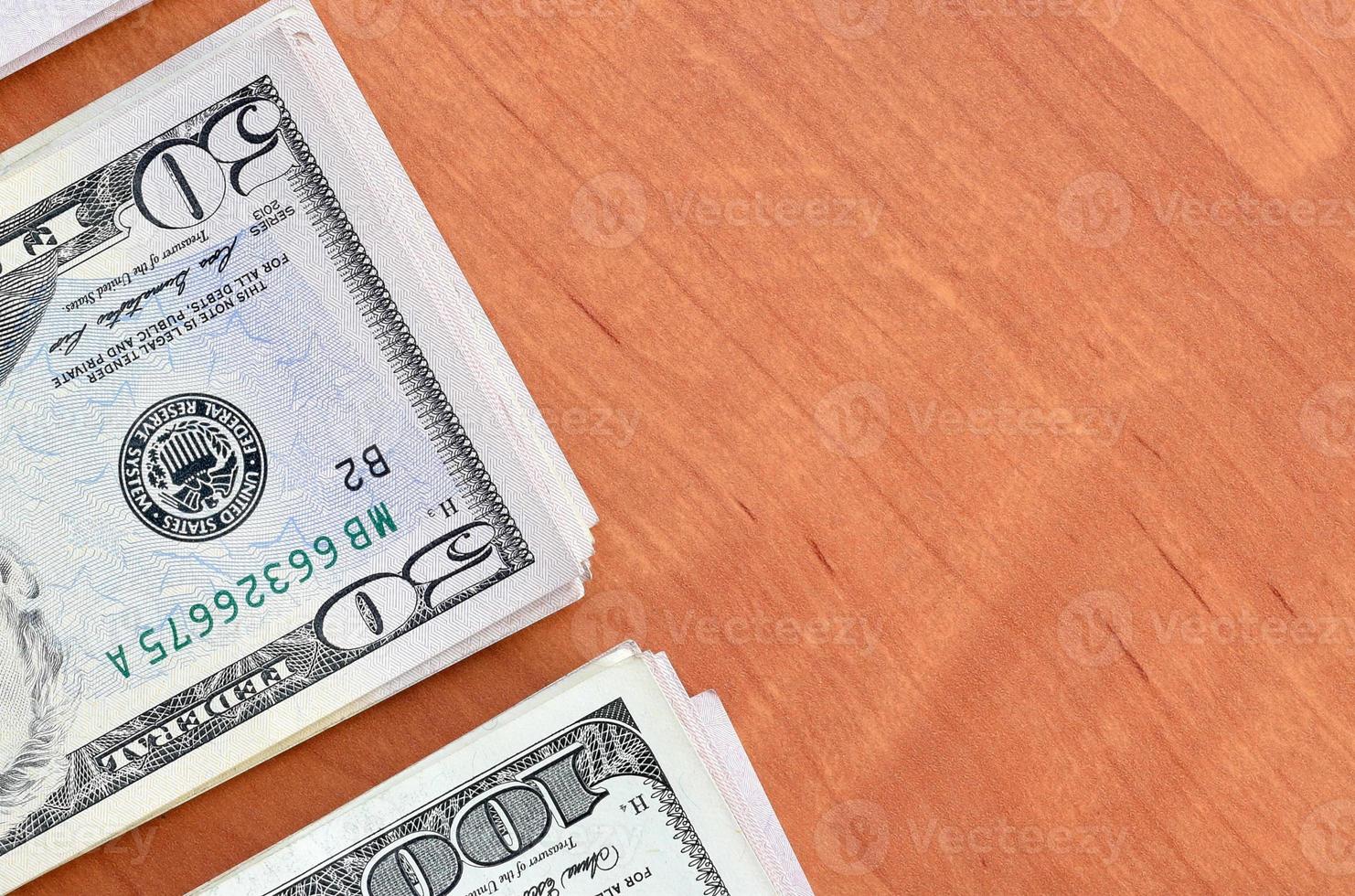 Stacks of many one hundred and fifty dollar bills on wooden background surface close up. Flat lay top view. Abstract business concept photo