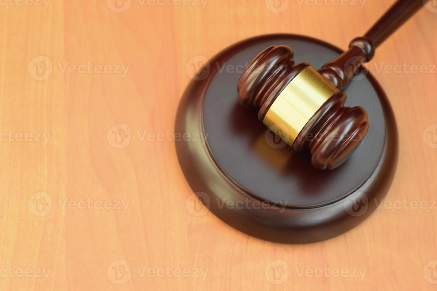 mazo de justicia en un escritorio de madera en una sala de audiencias durante un juicio judicial. concepto de ley y espacio vacío para texto. juez martillo foto
