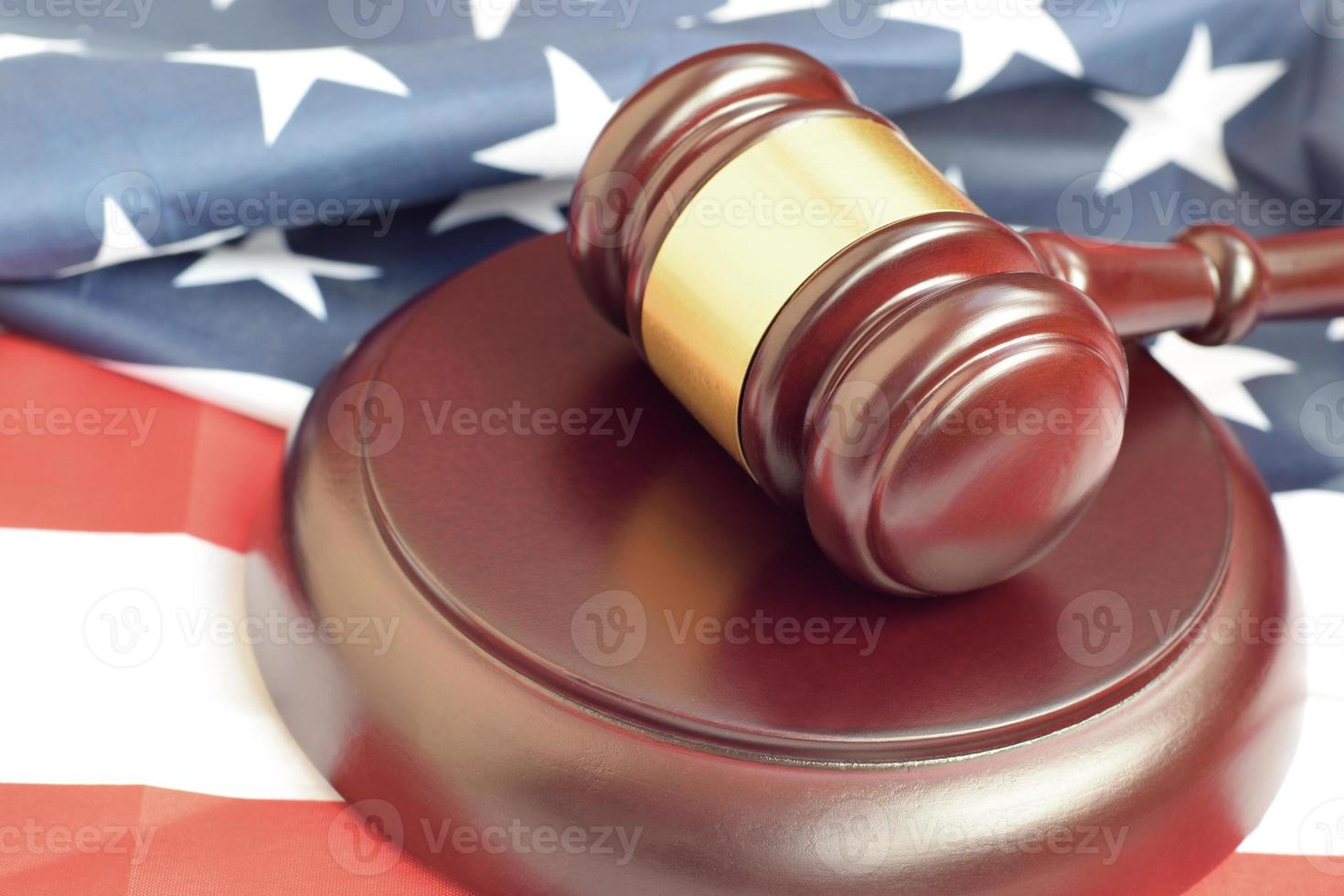 Justice mallet on United States flag in a courtroom during a judicial trial. Law concept and empty copyspace. Judge hammer photo