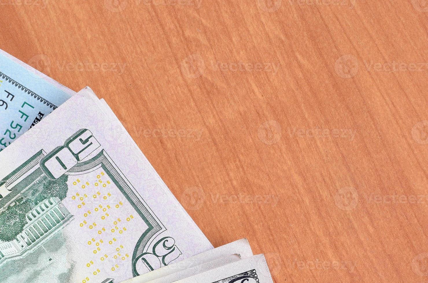 Stacks of many one hundred and fifty dollar bills on wooden background surface close up. Flat lay top view. Abstract business concept photo